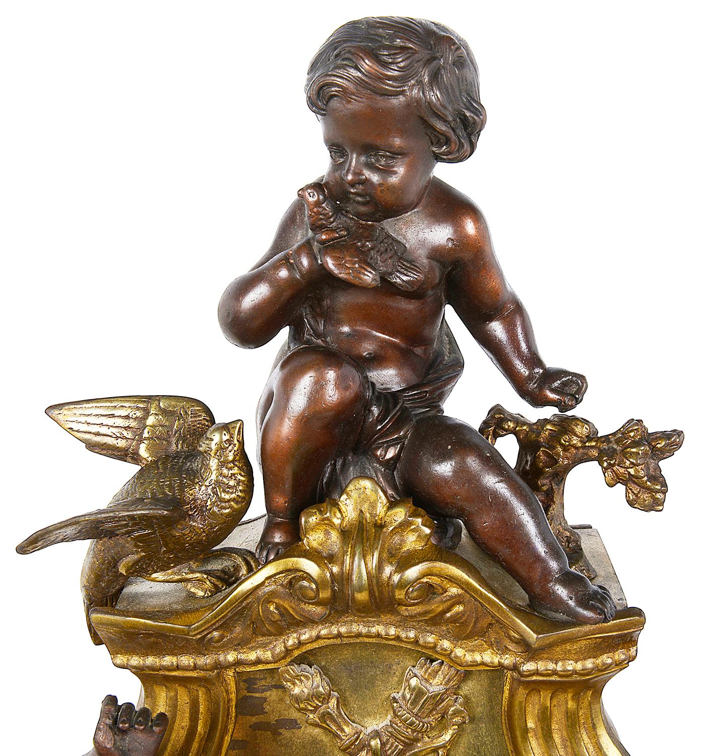 An impressive late 19th century French gilded ormolu and patinated bronze mantel clock. Having three putti mounted to the top each playing musical instruments. The clock having an eight day duration, striking on a bell every hour and half hour,