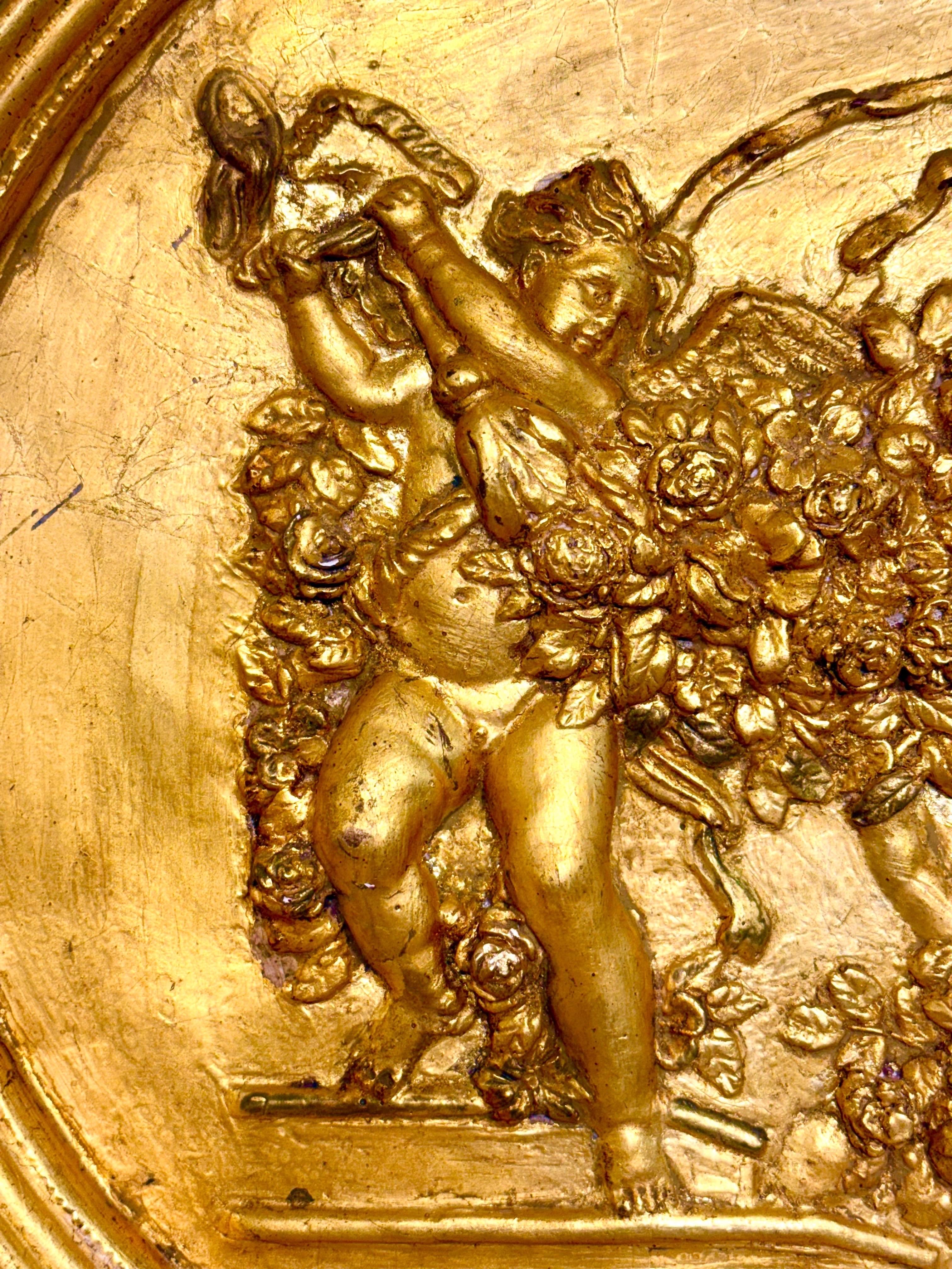Sculpté à la main Bas-relief ovale en plâtre doré du XIXe siècle avec Putti et guirlandes en vente