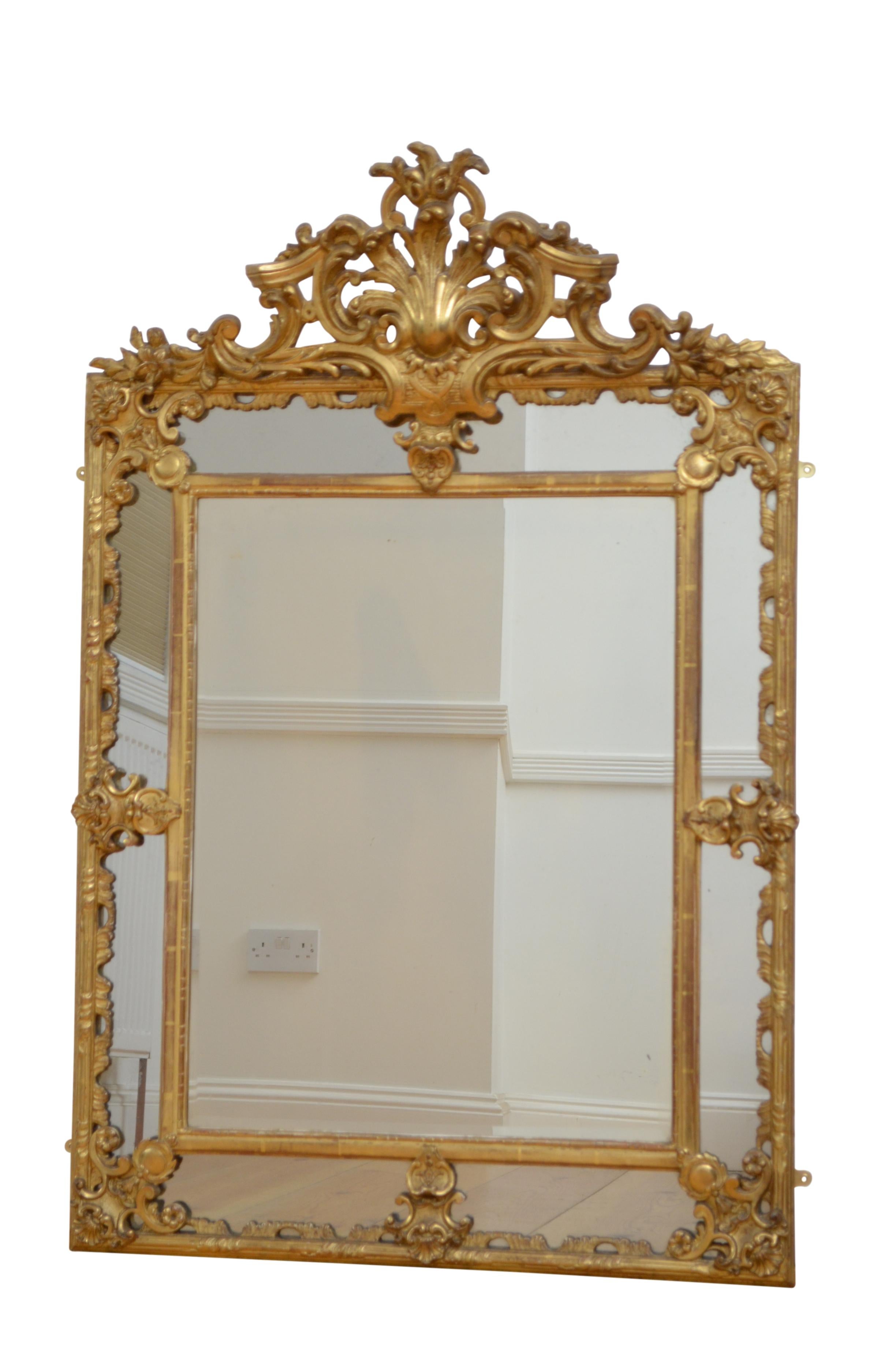 P0192 Fine antique giltwood wall mirror, having original bevelled edge centre mirror flanked by rectangular mirrors in moulded and finely carved gilded frame with elaborate scroll crest to centre. 
This antique mirror retains its original bevelled
