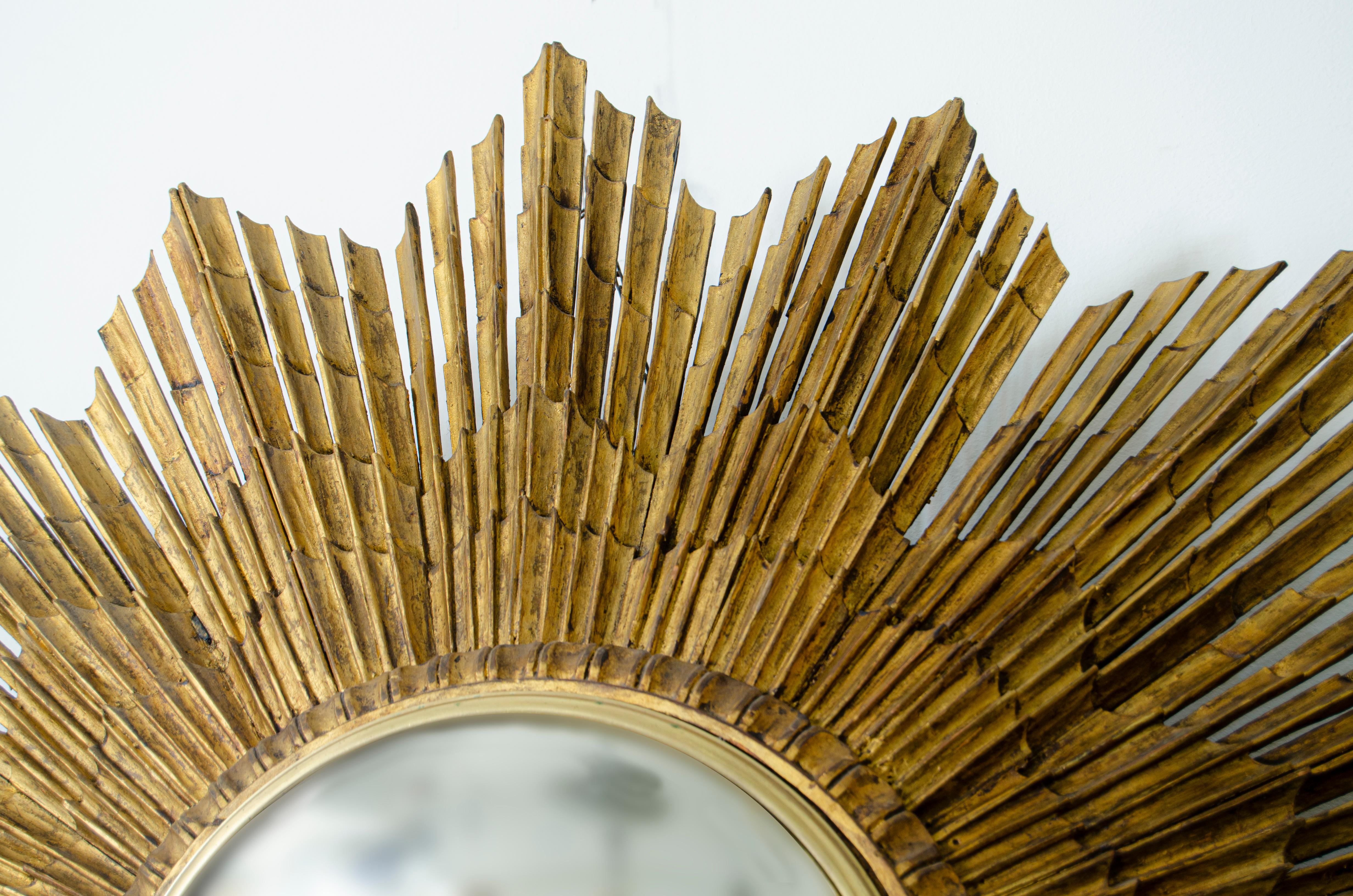 19th Century Gilded Wood Sunburst Mirror. Original gilt finish on the finely carved wooden trays, with original mirror. 

France, CIRCA 1950.