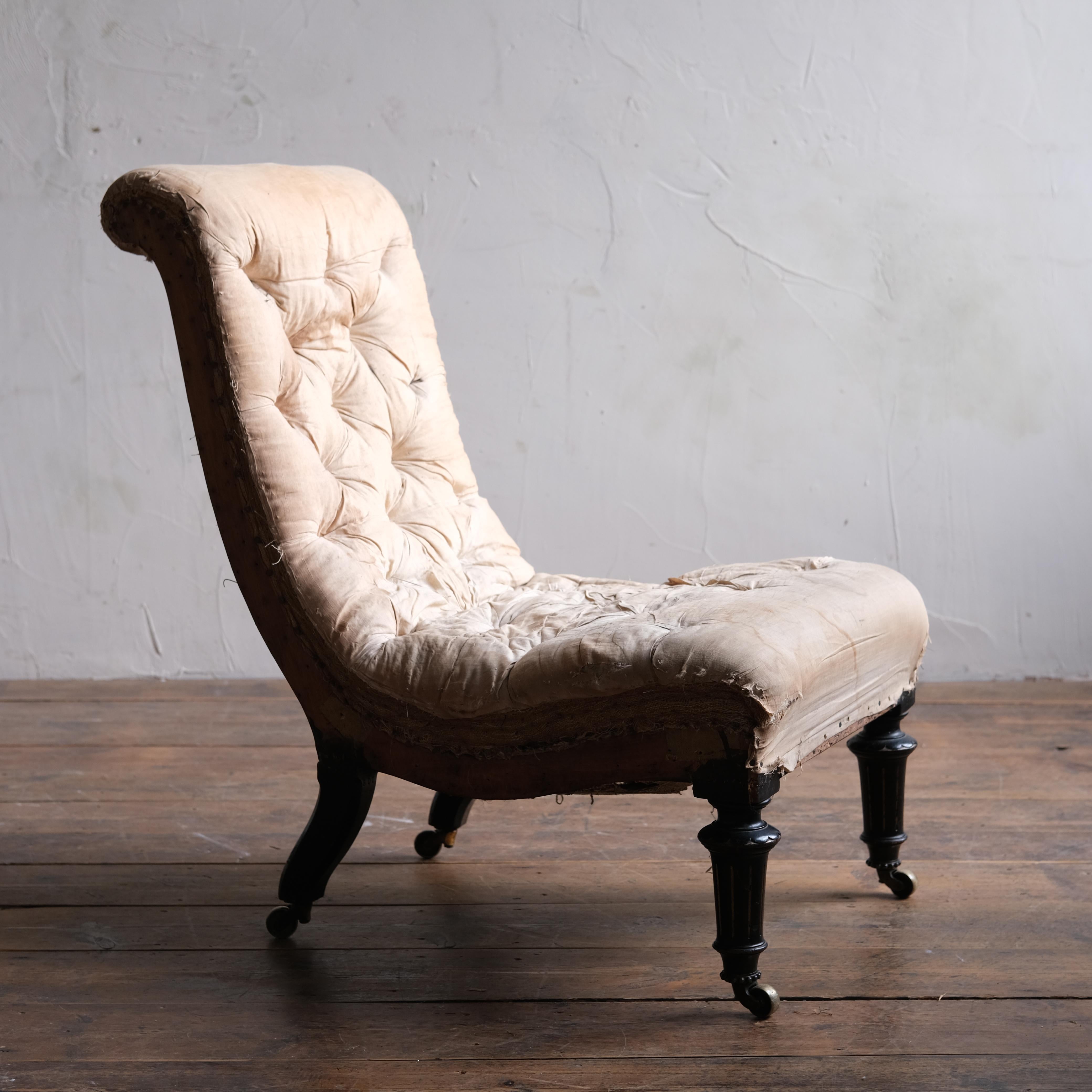 A very good quality aesthetic movement slipper chair by Gillows. Raised on decorative ebonized legs with the original Cope & Collinson 'Strong' brass casters. In original condition and retaining its full buttoned fillings only requiring upholstery.