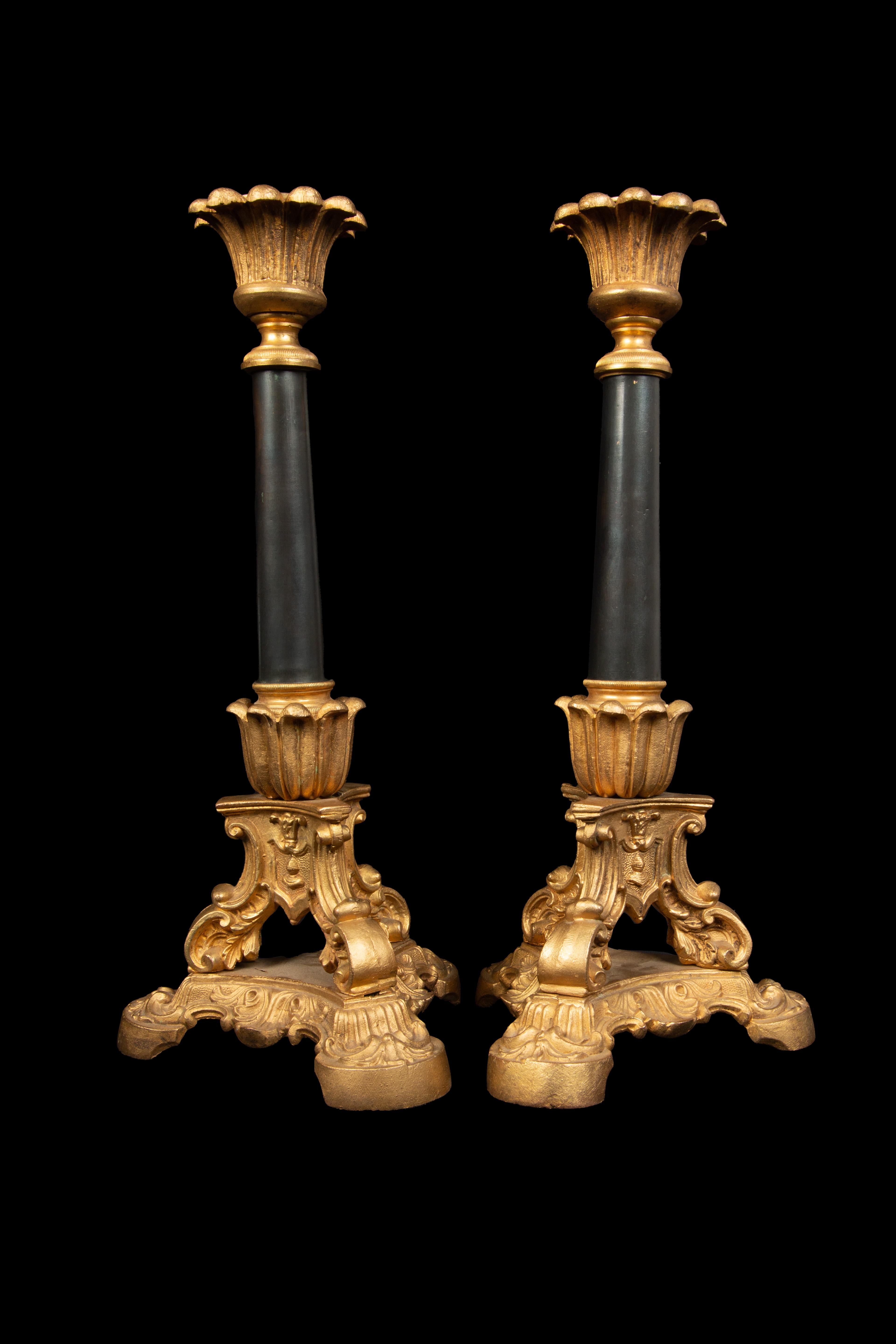 Kerzenständer aus dem 19. Jahrhundert: Diese 13 Zoll hohen Kerzenständer aus vergoldeter Bronze und schwarz patiniertem Metall haben einen eleganten Dreibeinfuß. Mit ihrer zeitlosen Ausstrahlung bringen sie Raffinesse und historischen Charme in