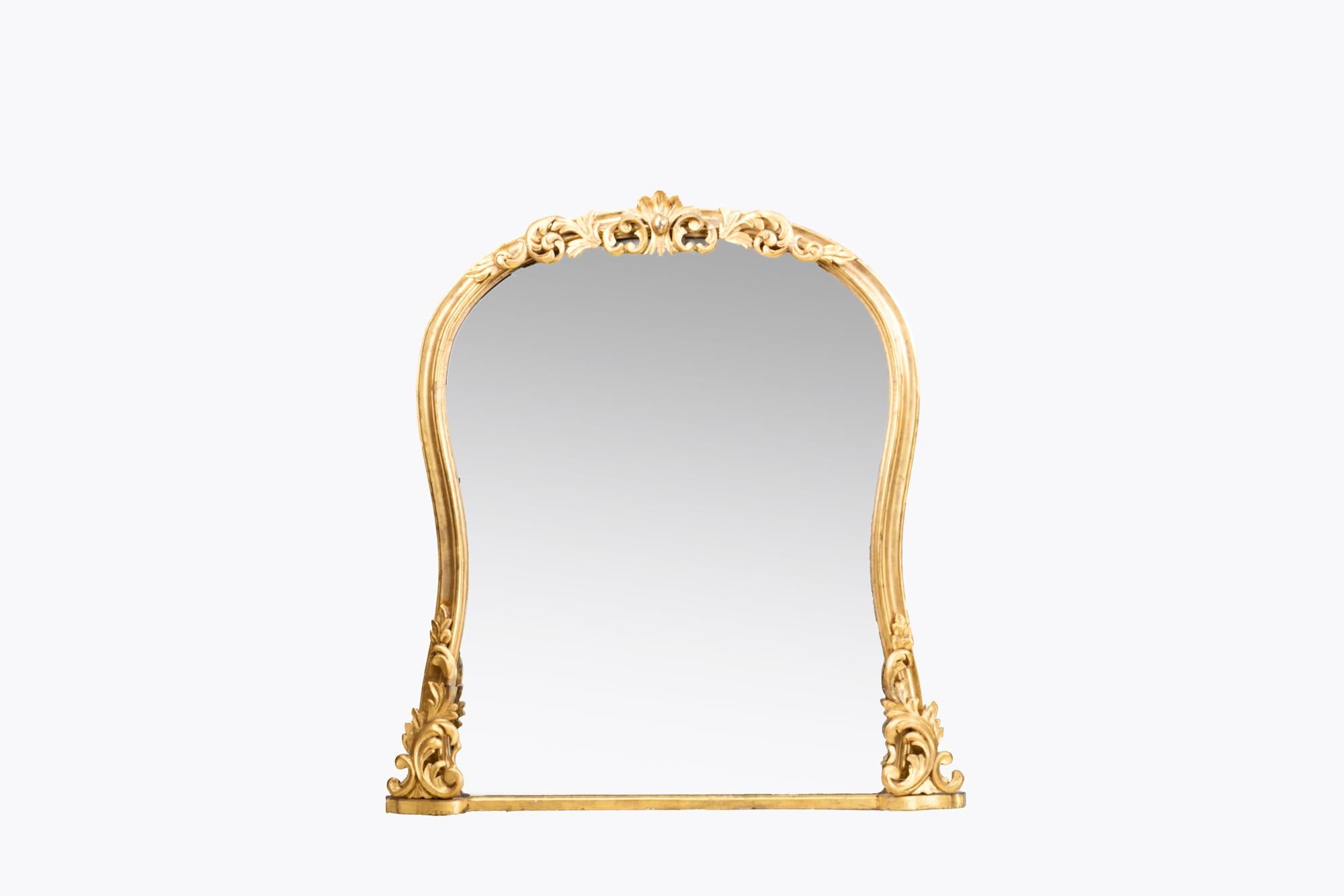 Miroir de cheminée du 19e siècle, de forme cintrée, avec un cadre en bois doré élégamment sculpté et cannelé, avec des motifs de feuilles d'acanthe et de C.I.C. sculptés sur le dessus et la base.