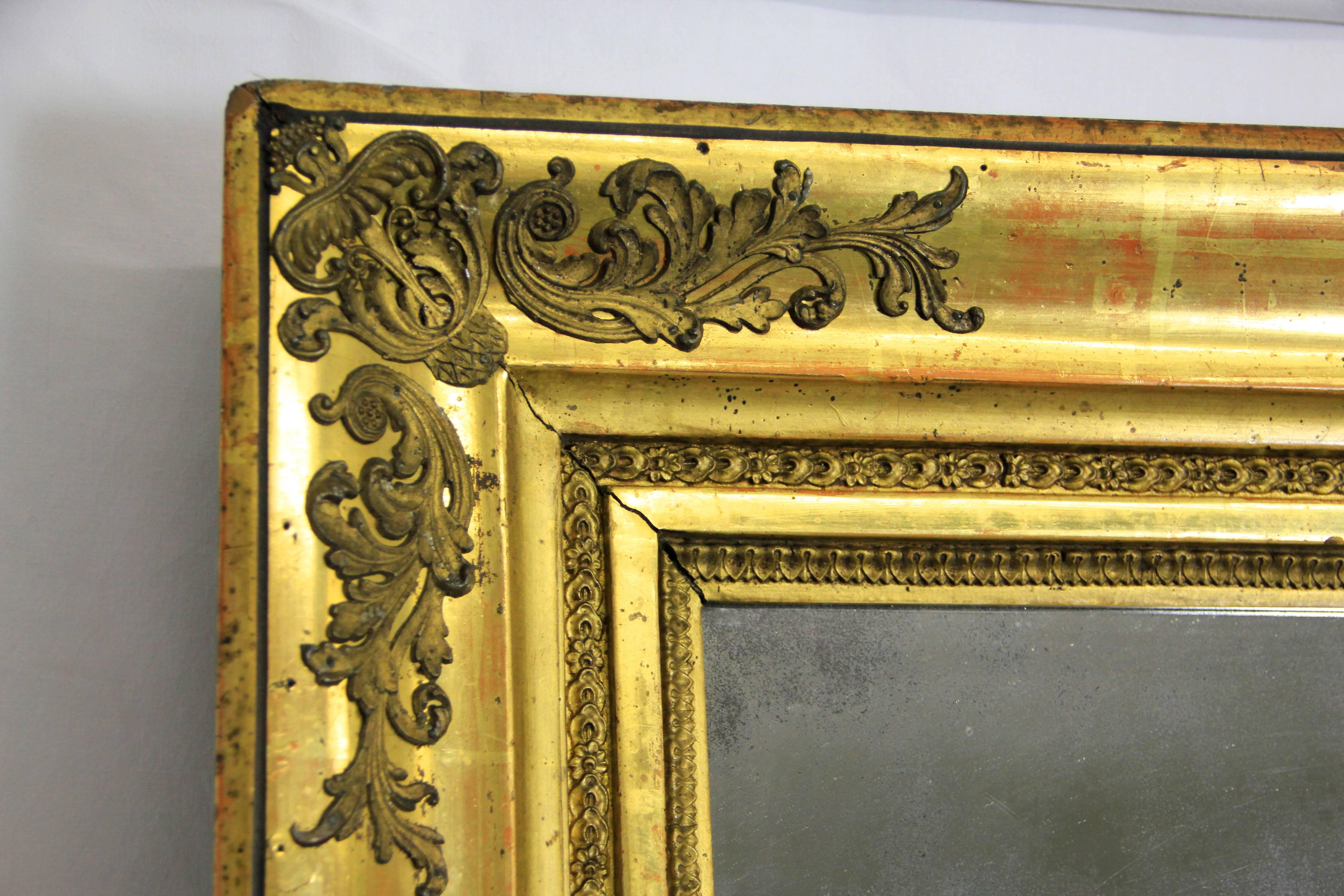 Amazing early 19th century gilt Biedermeier wall mirror out of Austria from circa 1830. This large antique mirror comes with an overlapped substructure made of spruce wood (you can see one of the wooden nails on picture 8) and a precious gold leaf