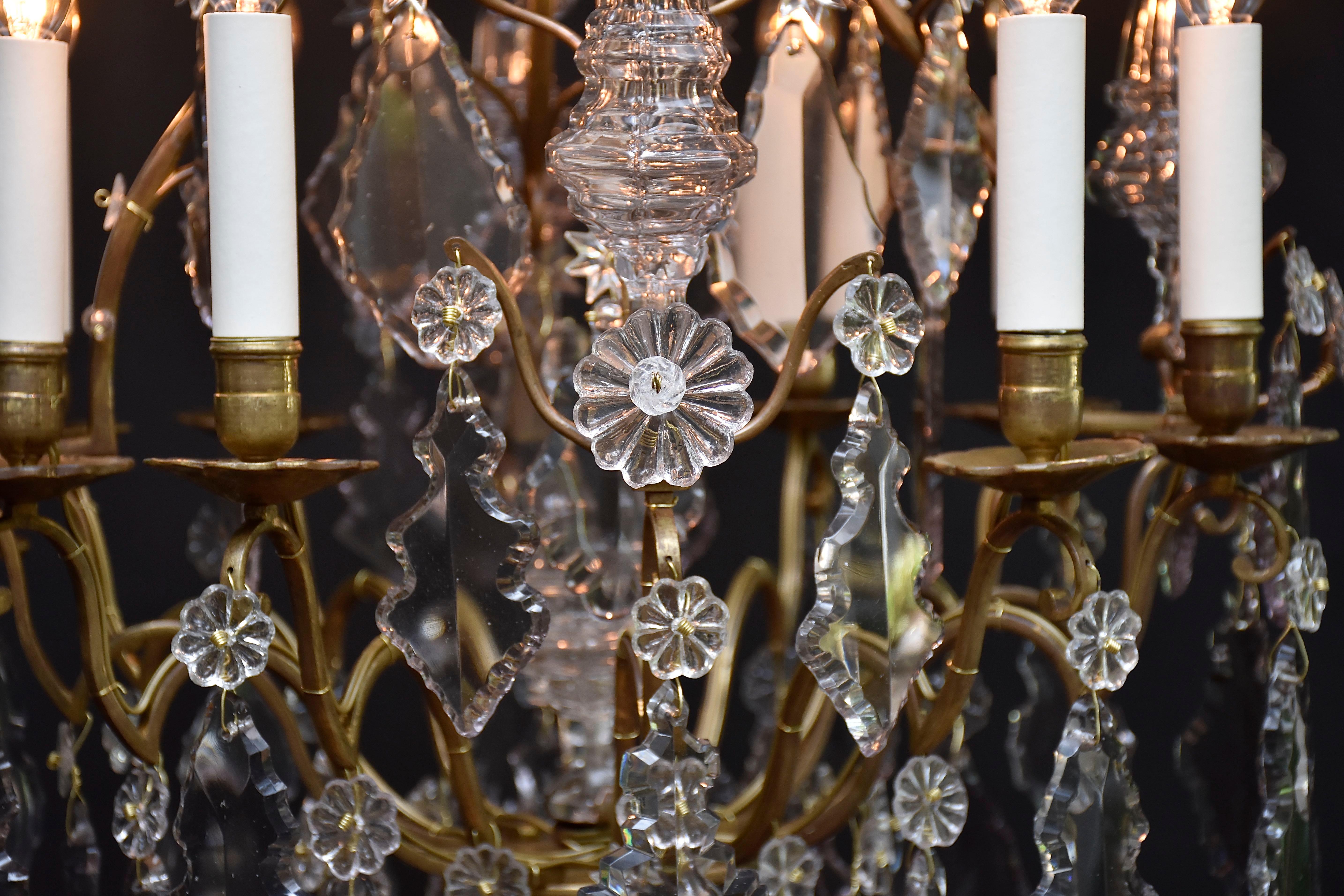  Maravillosa araña francesa de 8 luces de estilo Luis XV. 
 Marco de bronce dorado adornado con rosetas de flores. Forma de jaula.
En los brazos de la 