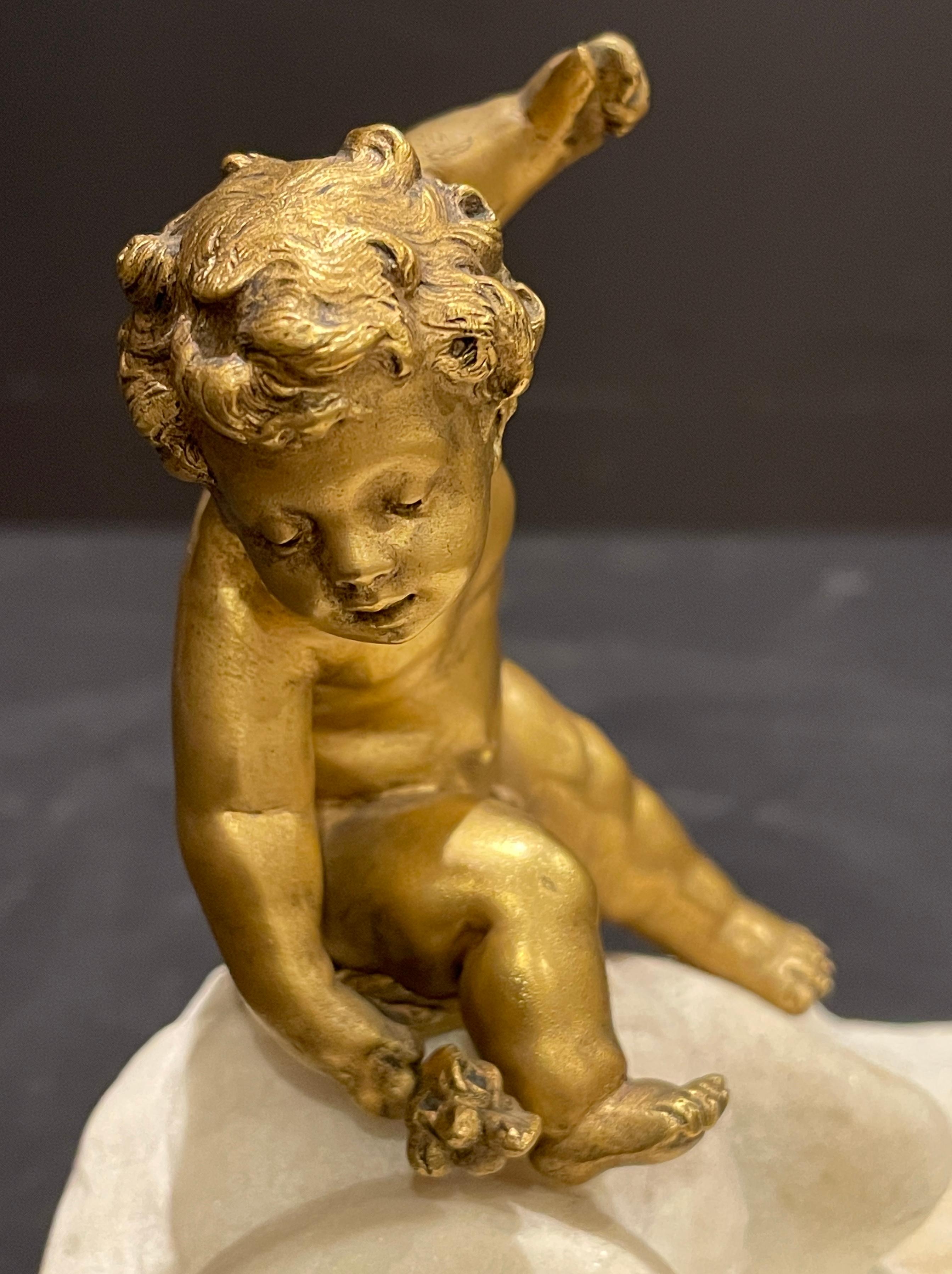White Carrara marble carved sea shell with gilt bronze child reaching for a patinated bronze crab. Wonderful ring tray for bedside or even a soap dish. Or just a whimsical tabletop sculpture.