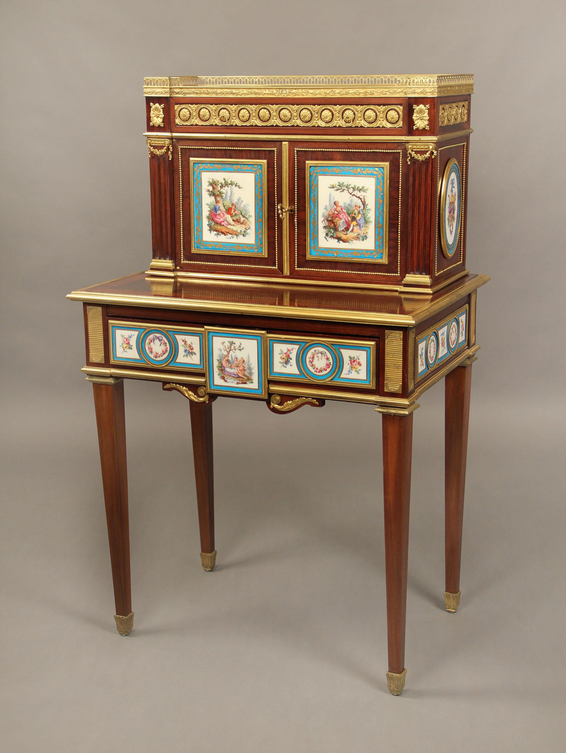 Meravigliosa placca in bronzo dorato e porcellana di Sèvres della fine del XIX secolo, Bonheur Du Jour

Il piano con galleria a tre quarti traforata e piano in marmo bianco sopra un cassetto singolo, una coppia di ante con pannelli a placca in
