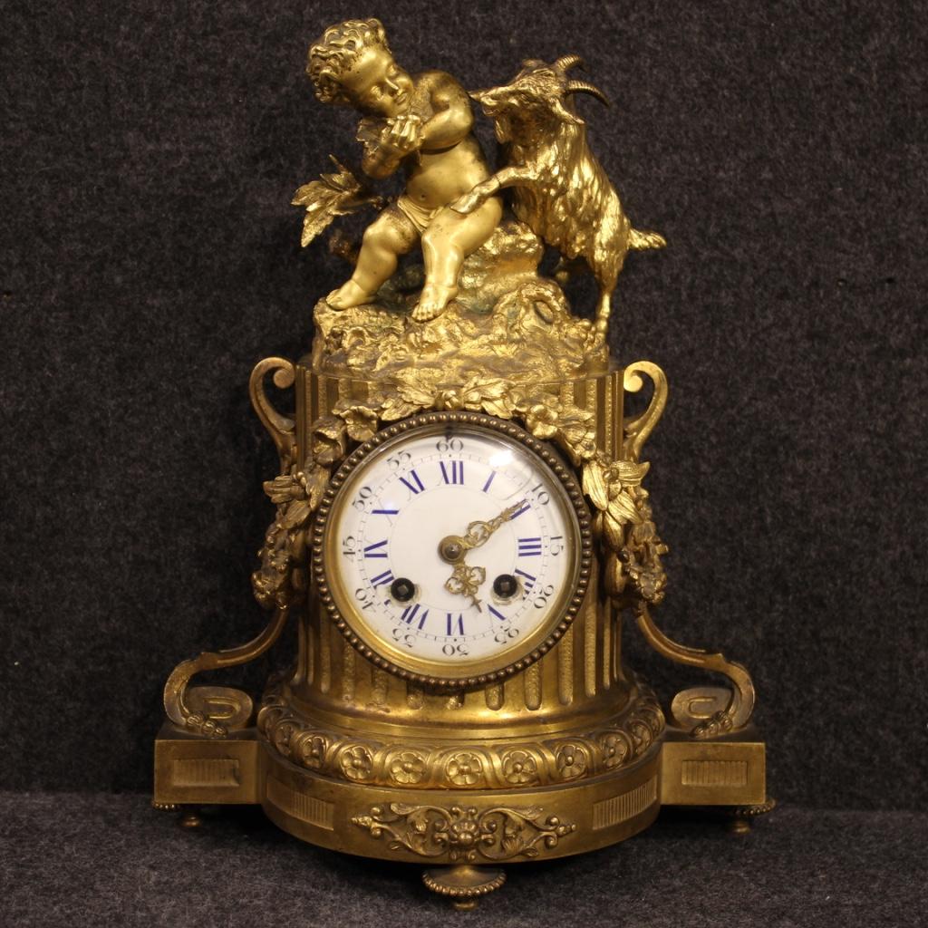French clock from the late 19th century. Finely chiseled and gilded bronze object adorned with a sculpture of an angel and kid. Clock with glazed ceramic dial with some small chips and signs of restoration (see photo) and hands in gilded and
