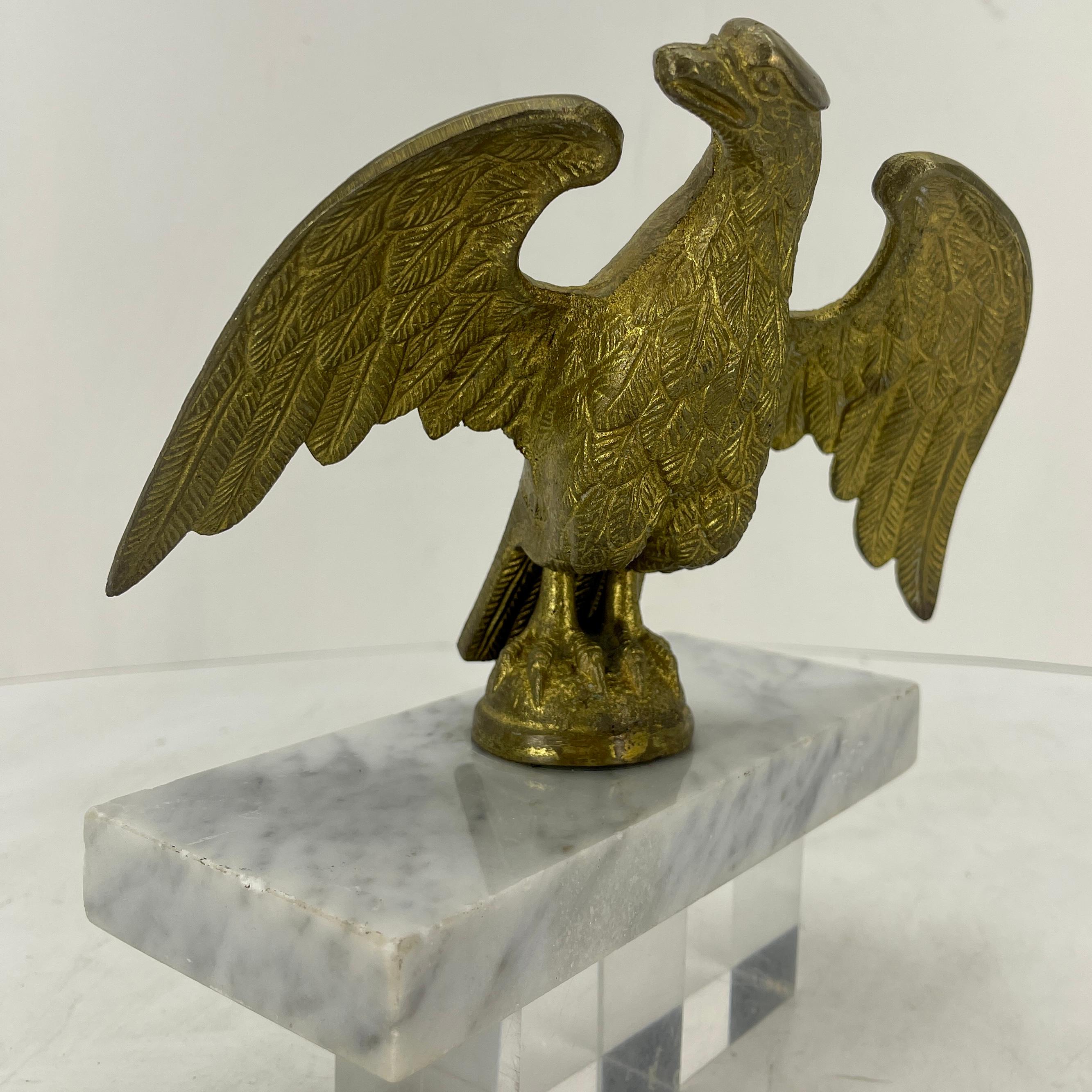 Sculpture italienne en bronze doré représentant un aigle sur une pièce rectangulaire en marbre blanc de Carrera. La grande qualité du travail de dorure et le jeune âge de la sculpture de l'aigle la rendent exceptionnelle.
