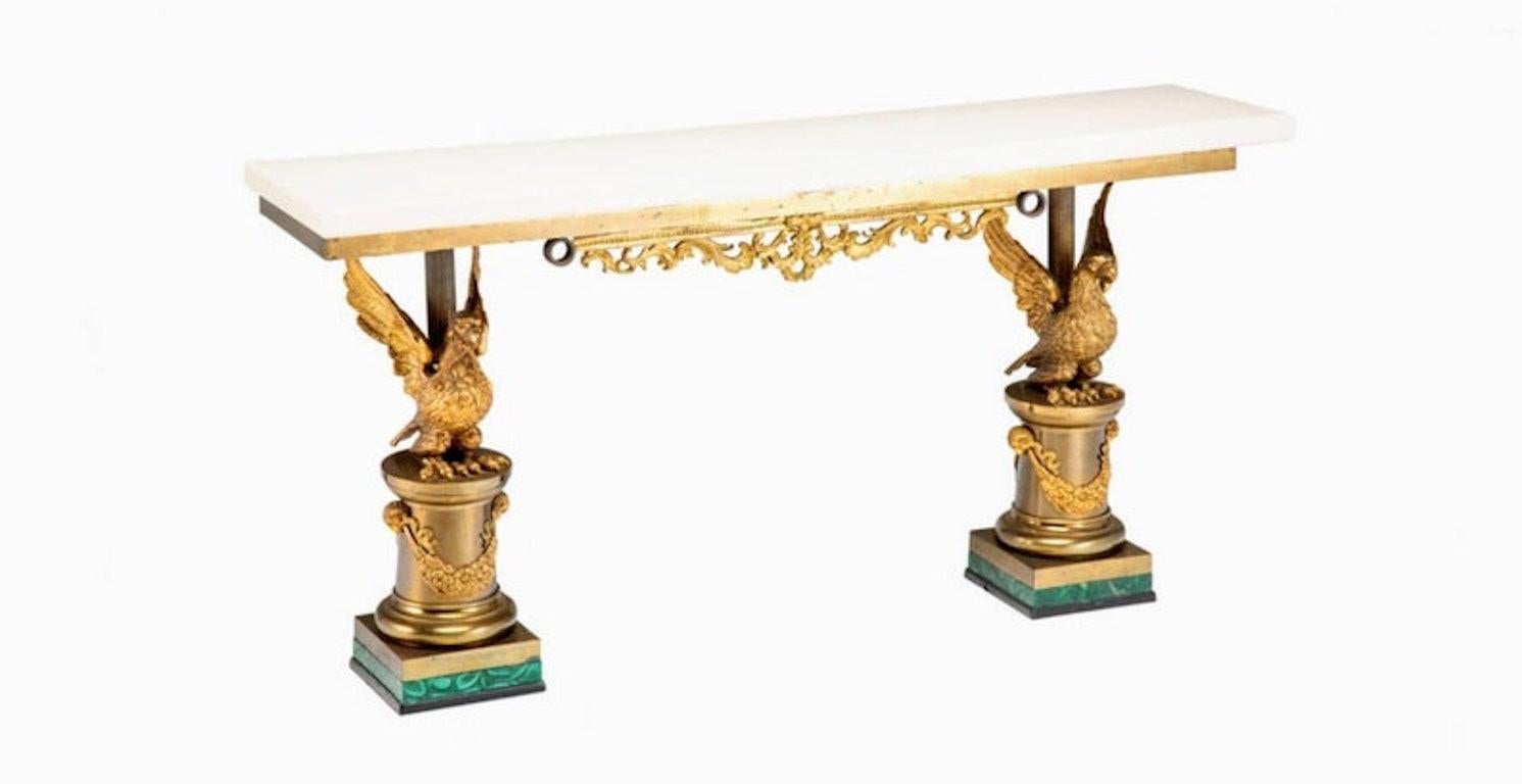 A magnificent Neoclassical gilt bronze and malachite console table. The regal European antique (likely French) hand-crafted from 19th century and later elements, features a pair of large richly detailed gilded bronze Imperial (Royal) Eagles with