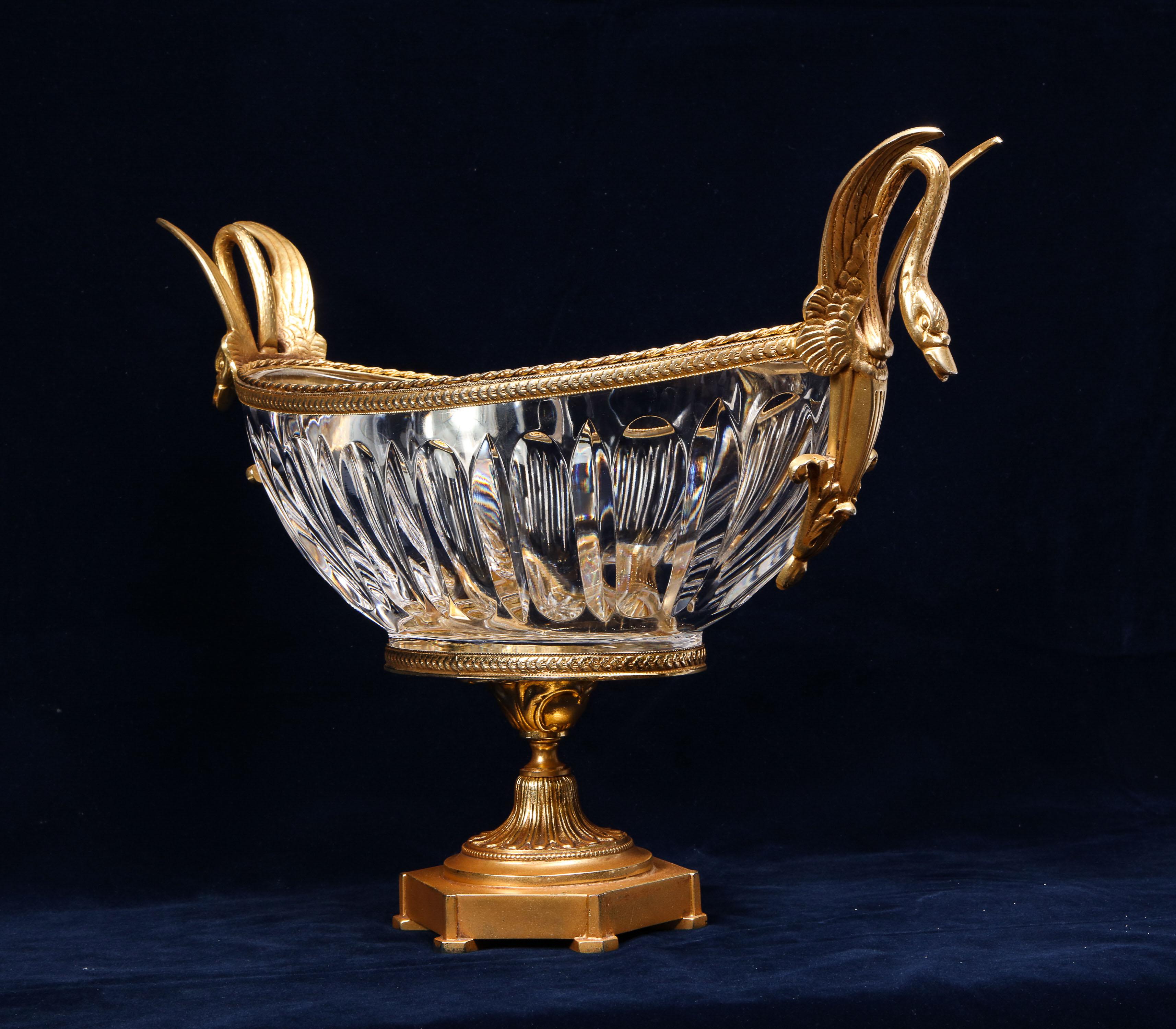 A beautiful Louis XVI style 19th century gilt bronze mounted crystal centerpiece with gilt bronze swan handles, attributed to Baccarat. The crystal is beautifully hand-diamond cut with long vertical concave patterns running around the bowl. The