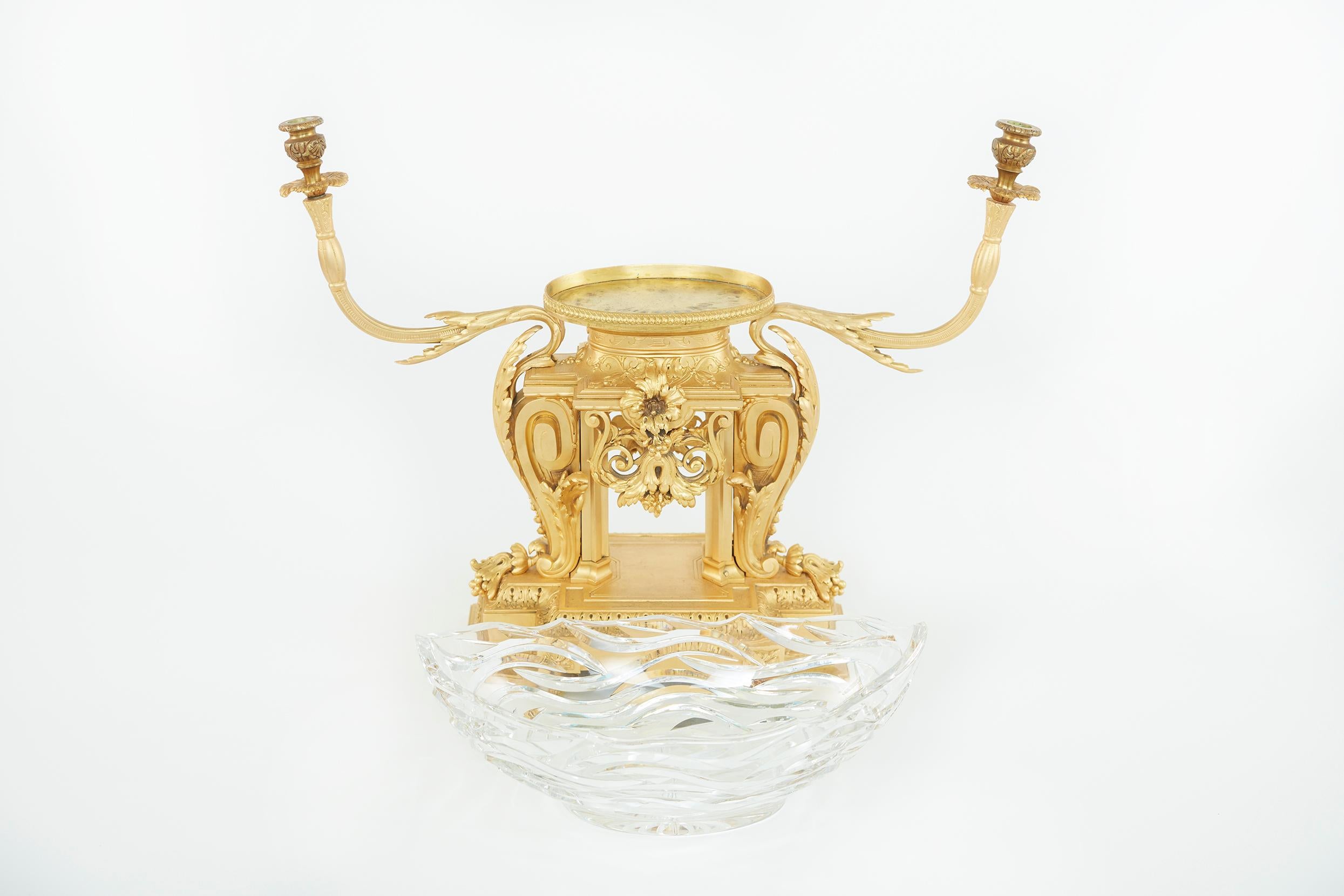 19th century gilt bronze mounted with cut glass holder decorative centerpiece with exterior design details. The centerpiece features a navette form bowl flanked by scrolling branches on a trestle base, cast with foliage. The breakfronted plinth on
