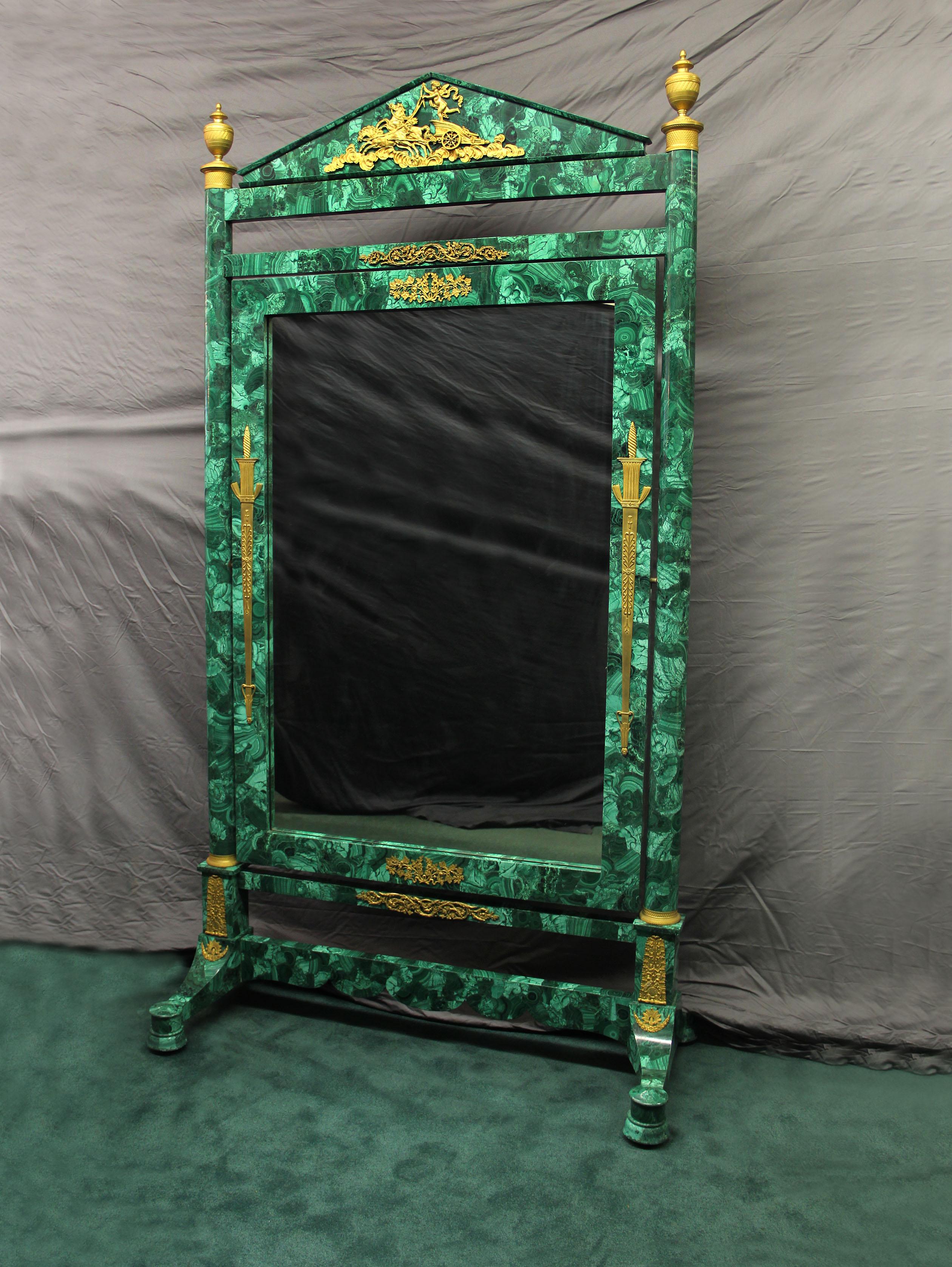 A beautiful late 19th century gilt bronze-mounted Napoleon III malachite dressing mirror.

Decorative bronze scene of a cheurb on a horse drawn chairot riding through the clouds. Bronze foliage and grapes decorate the top and base of the mirror.