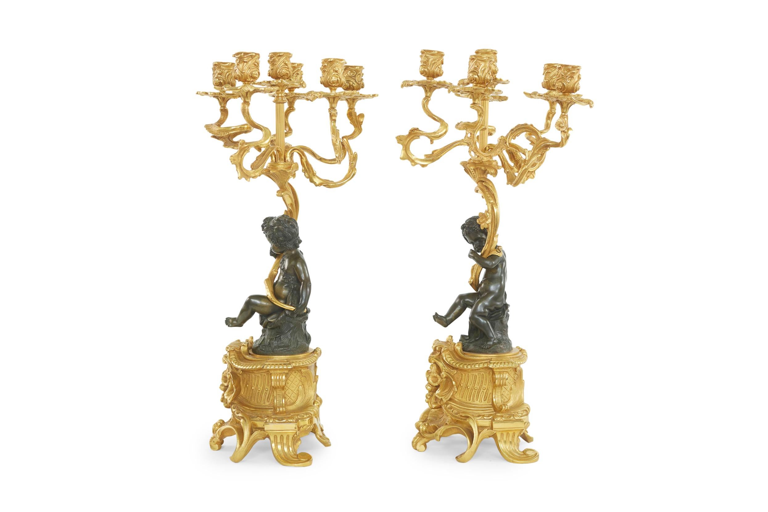 Vergoldetes Bronzepaar aus dem 19. Jahrhundert aus französischem Ormolu und figuralen sechsflammigen Kandelabern mit zwei Cherubinen. Jeder Cherub hält einen Leuchter, der barfuß auf einem Felsen sitzt und mit einem kleinen Stück Stoff bekleidet