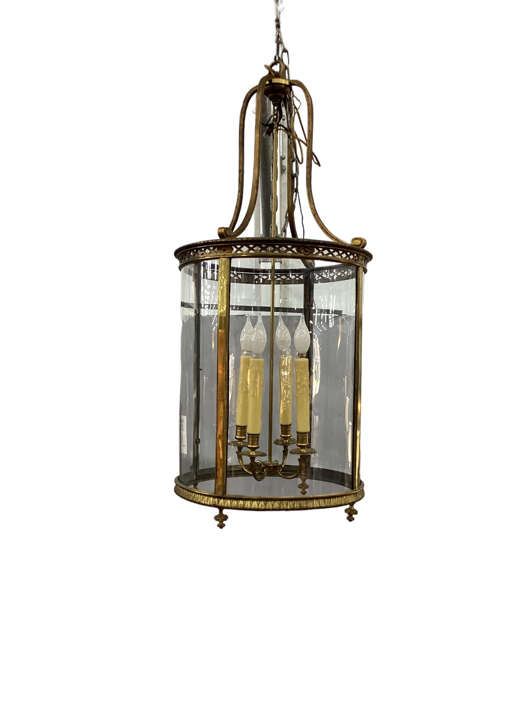 19th Century Gilt Bronze Regency Style Hall Lantern. Gilt bronze cage with curved glass panels, one panel opens up for changing light bulbs. Wired with four lights and in working condition. Each socket can accommodate up to a 60W light bulb.