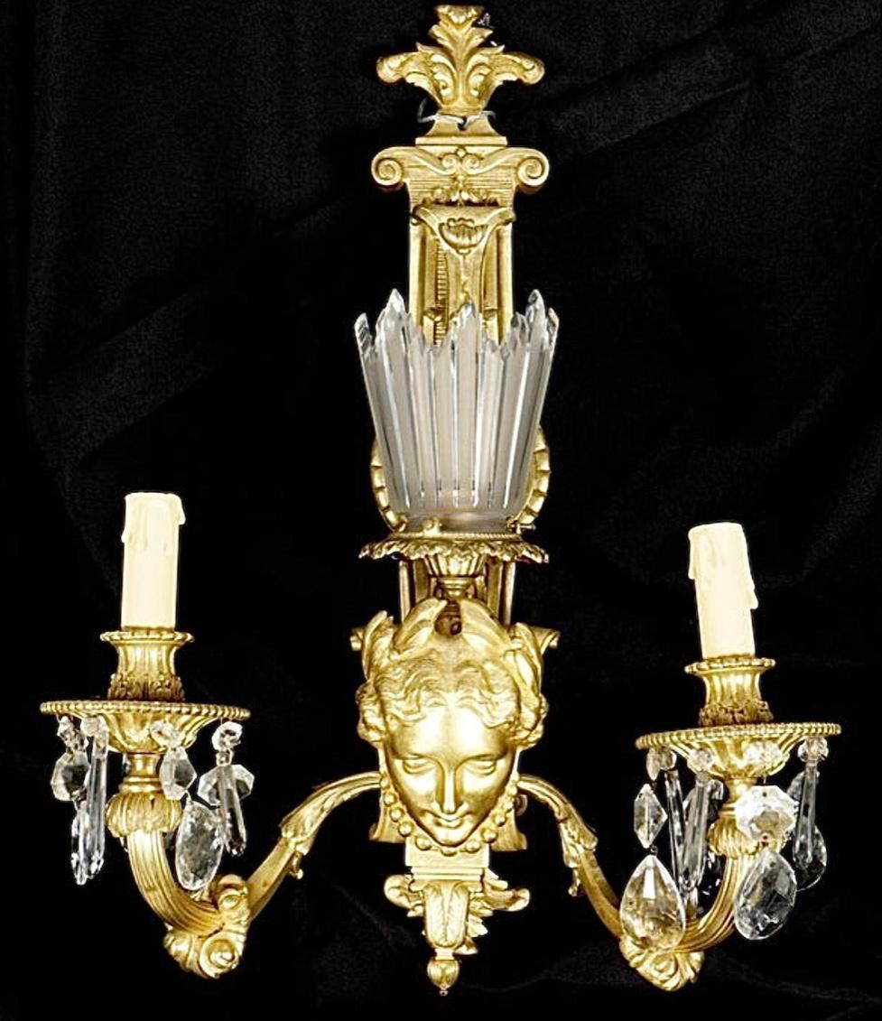 Large pair 19th century Belle Epoque gilt bronze gasolier sconces. Gilt bronze wall sconces, center female masque, raised foliate decoration, two arms, crystal drops and prisms. Later electrified.