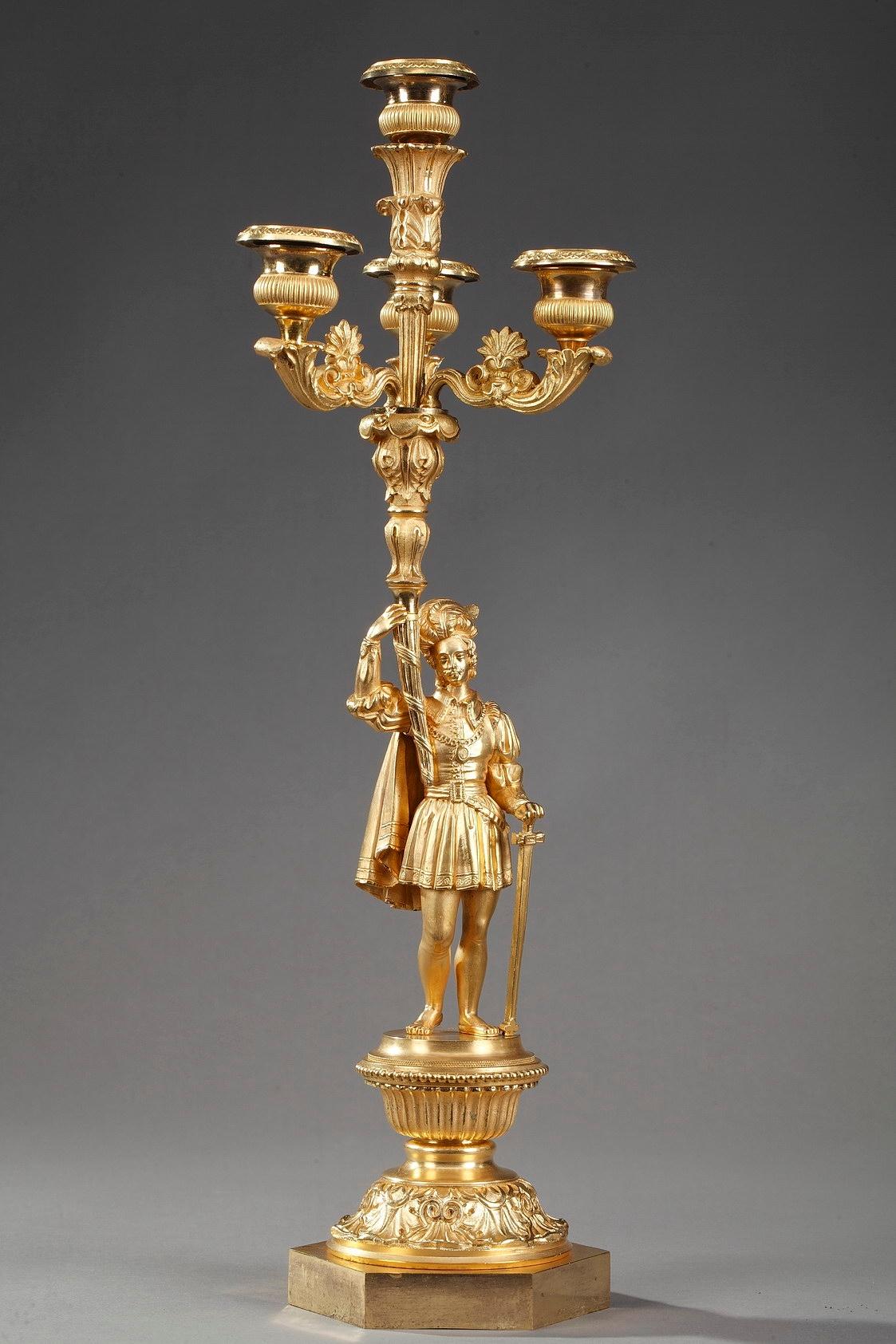 Two candelabra lamps, each with four branches, resting on a foliated and hexagonal base. They feature a courteous scene with an elegant lady giving a favour to a knight about to do battle. Courtly love was a medieval European literary conception of