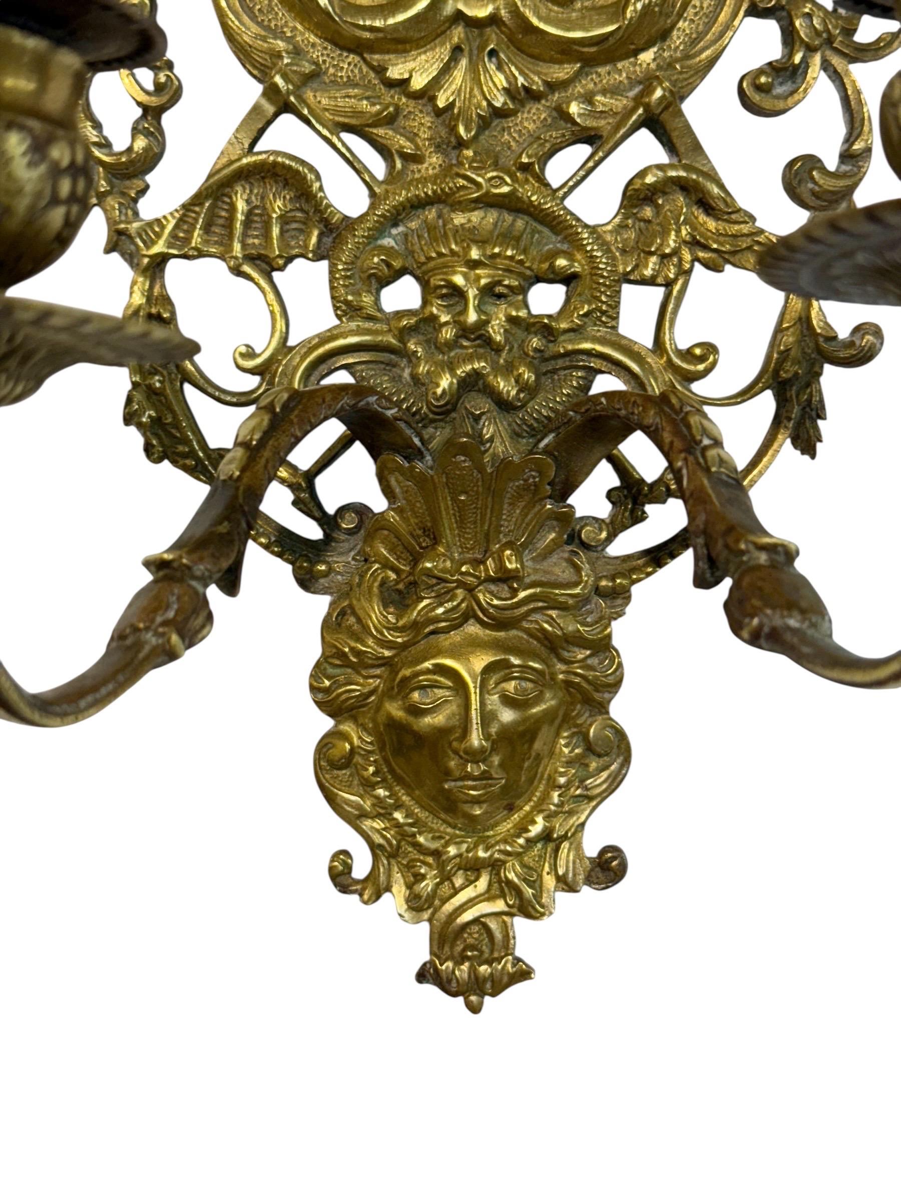 Questa magnifica applique in bronzo dorato è un esempio straordinario di artigianato del XIX secolo, riccamente decorata con figure allegoriche, maschere e ornamenti finemente cesellati. Progettato per contenere due candele, combina eleganza