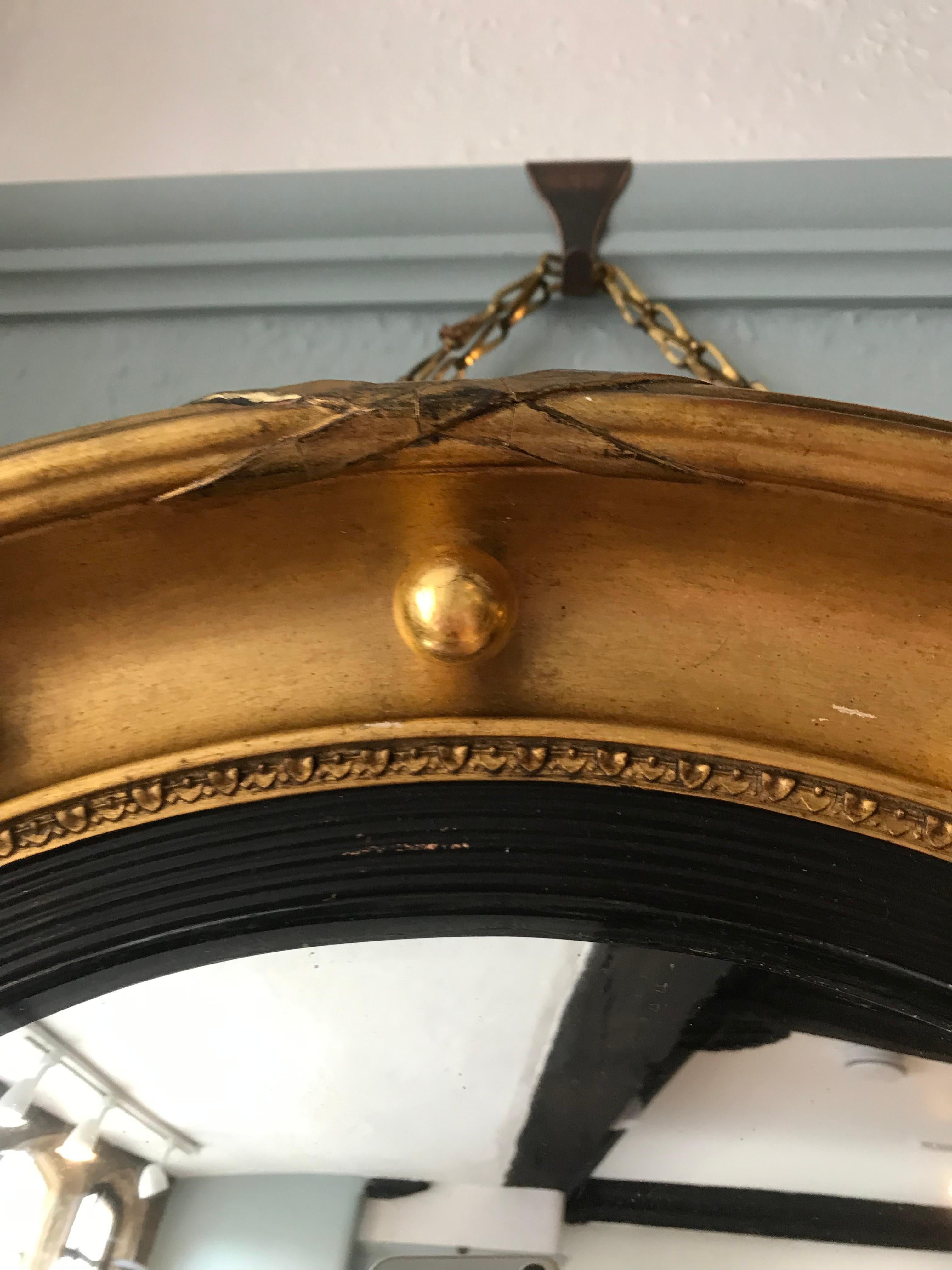 19th-century gilt convex mirror, the inner slip is reeded, ebonized and adorned with turned water gilded balls around the concave circumference. This mirror would add country house glamour to any room.