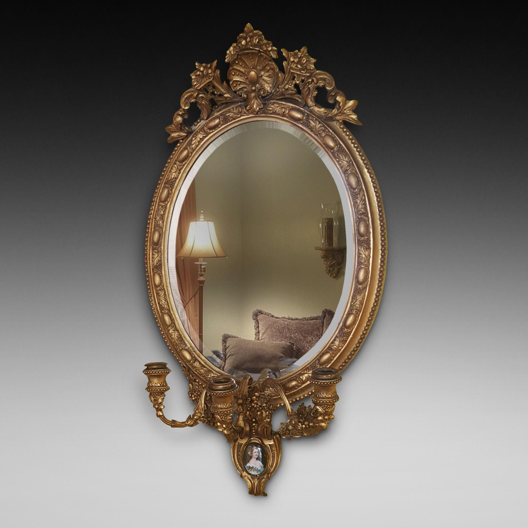 19th century gilt framed mirror with lower portrait plaque and three-candle branch holders, measures: 18
