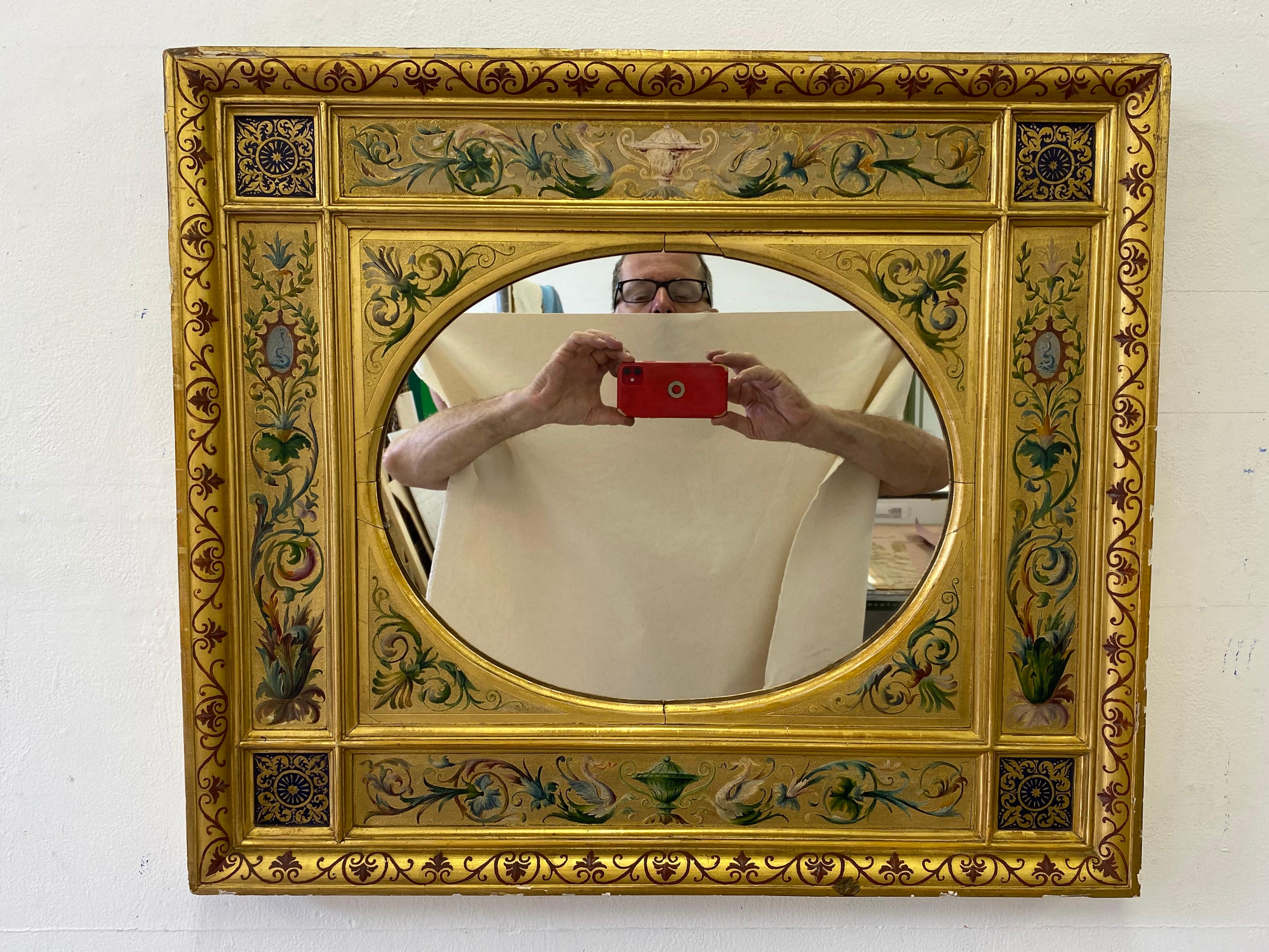19th century Italian gilt mirror with hand-painted designs over most of the frame. Divided frame design with an oval mirror. Nice quality painting with urns top and bottom.