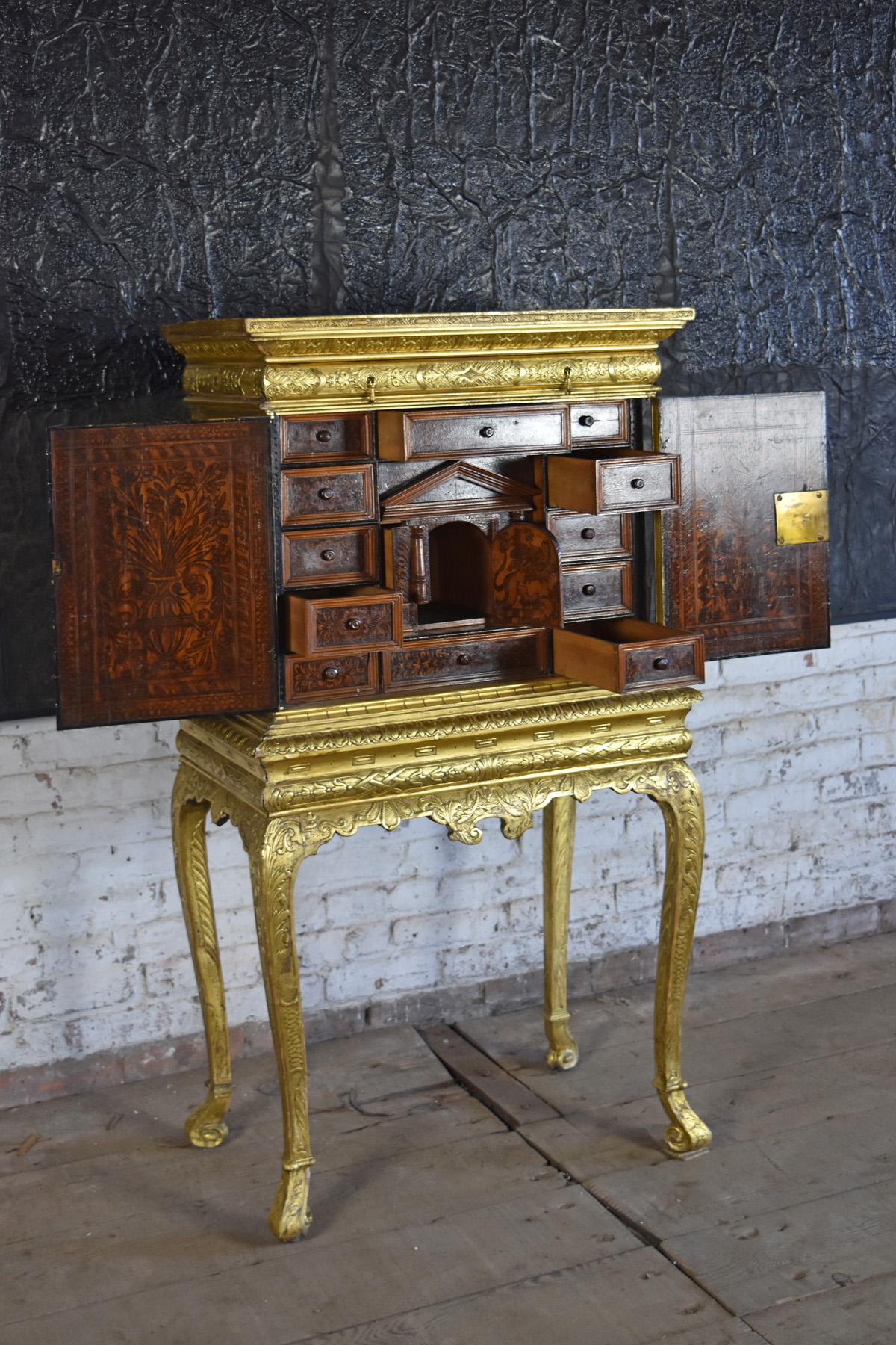 Petit, very decorative English gilt cabinet on stand, with an Italian 17th century poker-work interior featuring an intricate system of drawers, including numerous hidden ones. Reconfigured in the 19th century. The perfect jewelry cabinet.
The