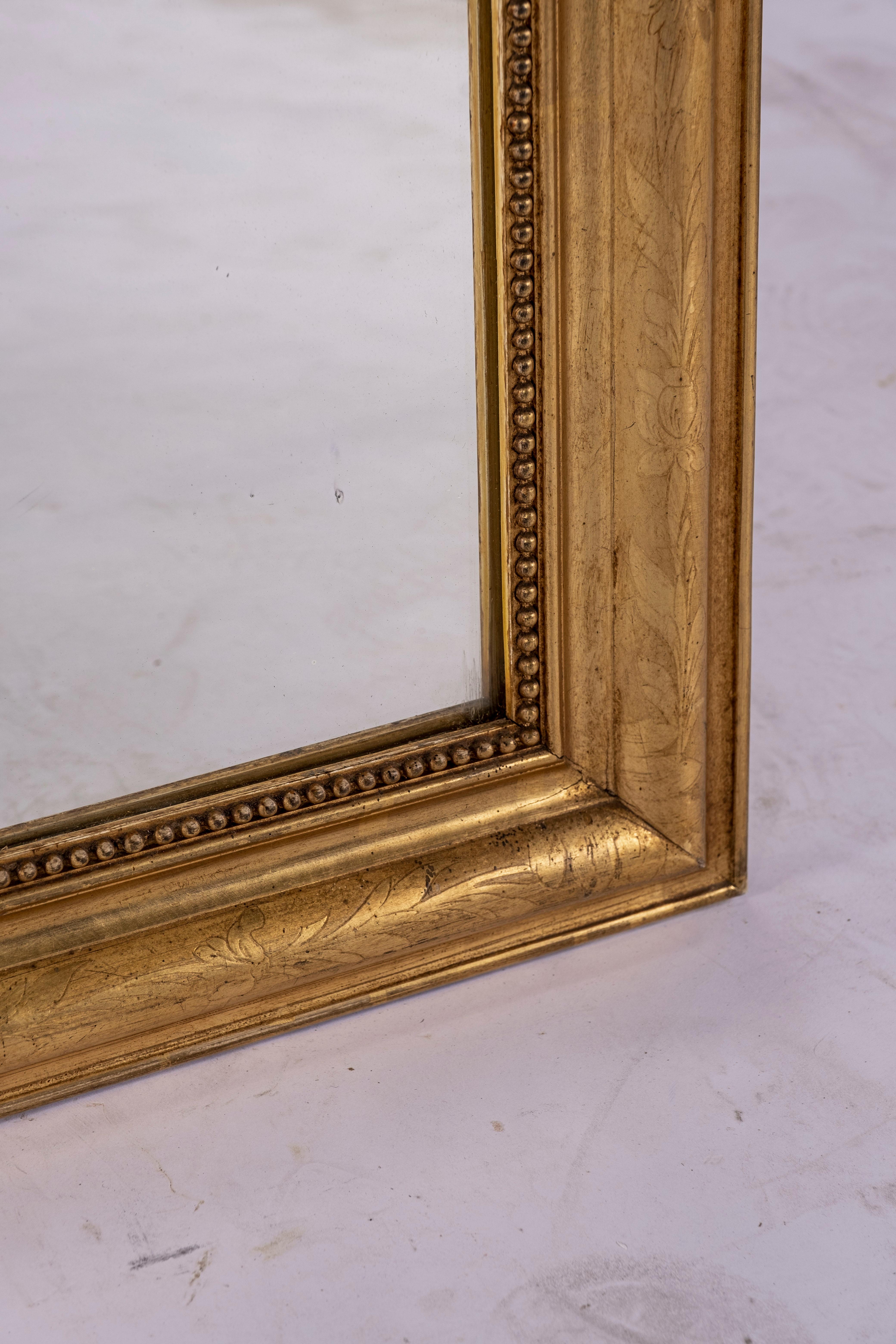Large gilt on black Louis Philippe mirror with flower and leaf etching to frame. Original glass. Original pine board back with Paris Stamp, circa 1880.