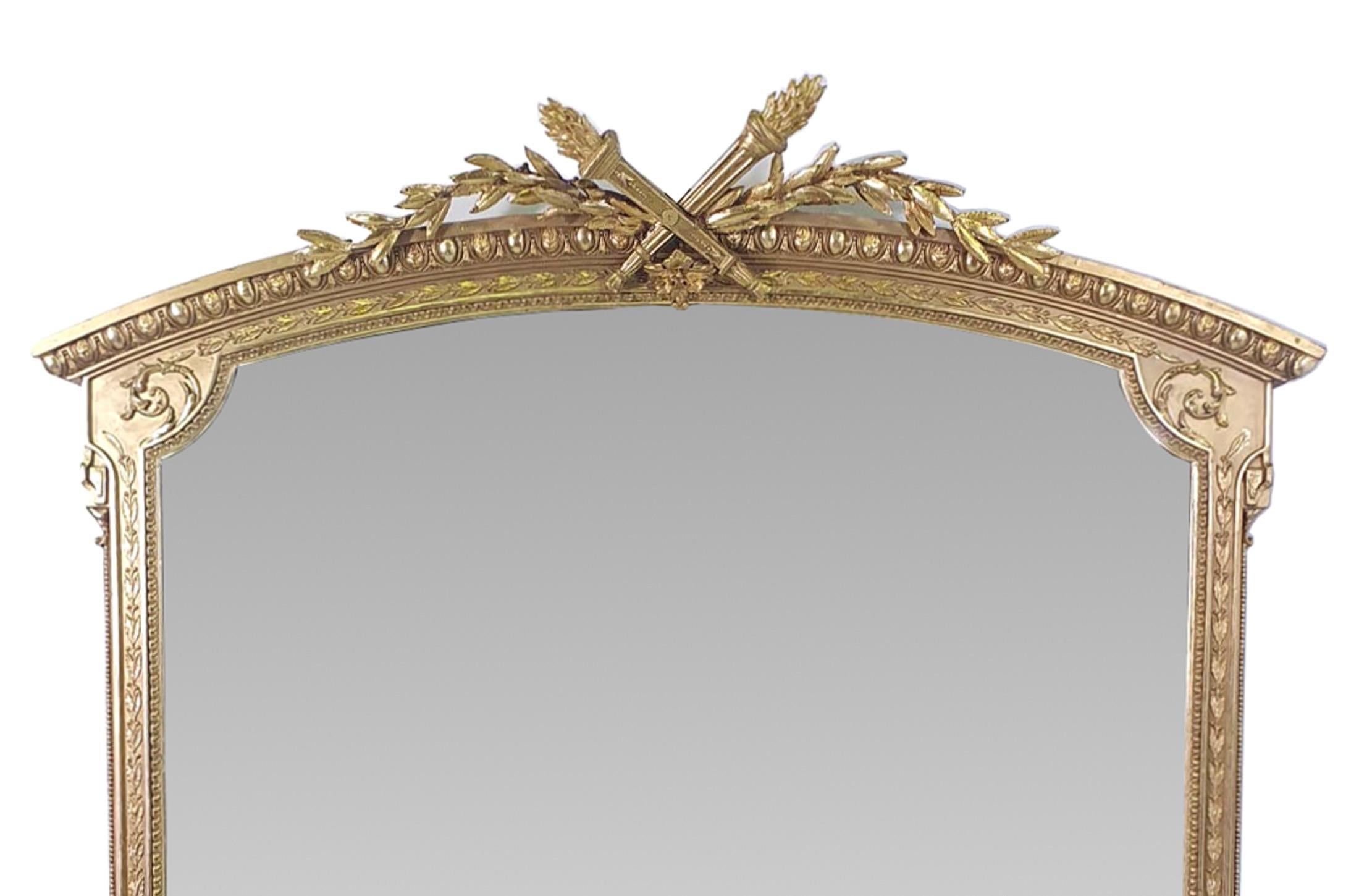 19th Century gilt overmantle mirror. The hand carved gilt wood frame with trailing foliate, S scrolls, beading, egg and dart motif detail surmounted with intricately carved crest of pair of Neoclassical torches flanked with trailing foliate.



 