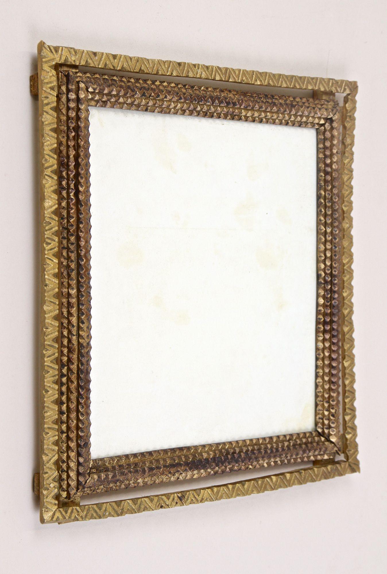 Unusual gilt Tramp Art photo frame from the period in Austria around 1870. Elaborately hand carved out of bass this antique rustic photo frame impresses with a double frame: the beautiful inner section shows the so-called 