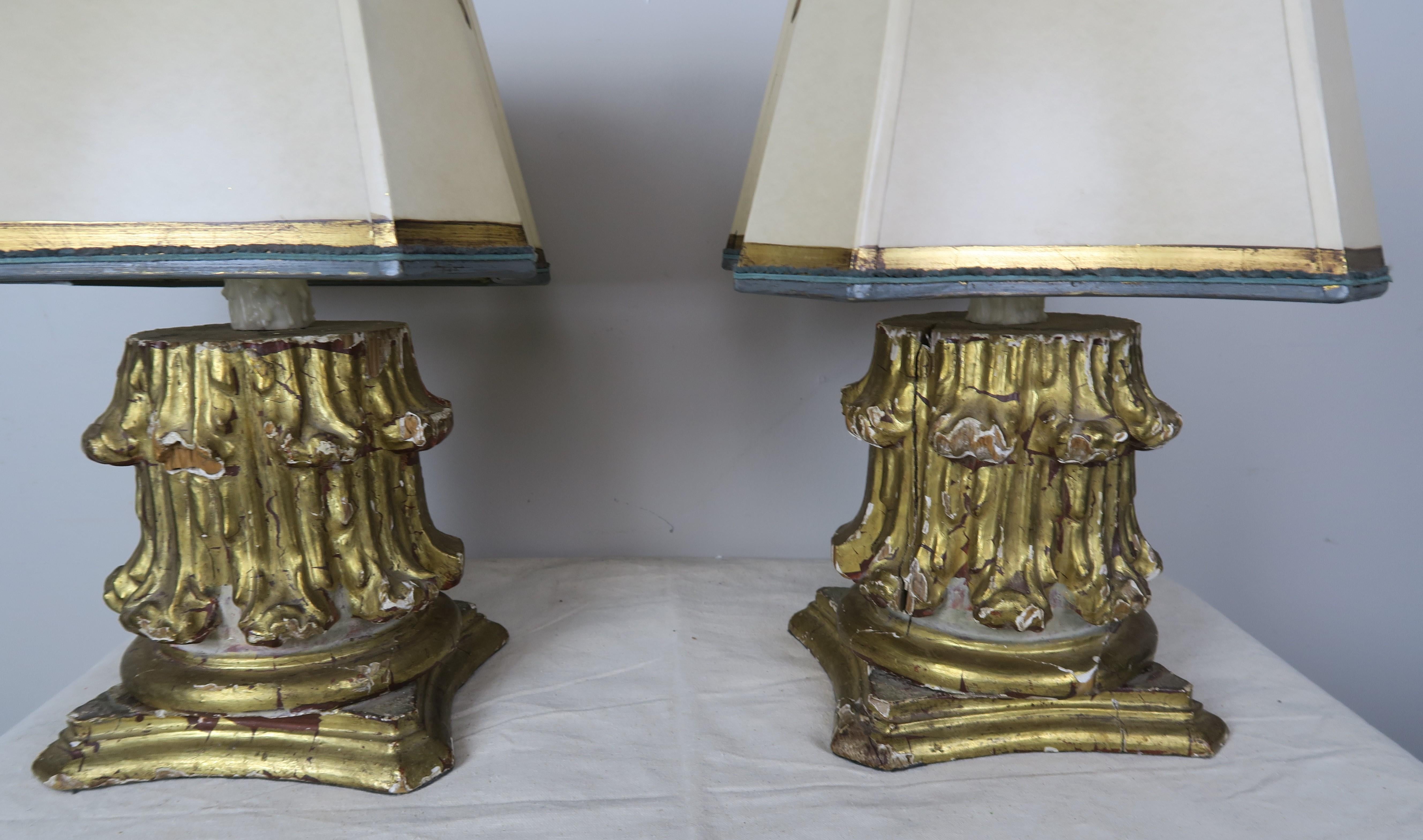 Pair of custom lamps made with 19th century Italian carved giltwood capitals mounted into contemporary lamps and crowned with custom gold detailed hand painted parchment shades in unique square shape to coordinate with the shape of lamp bases. The