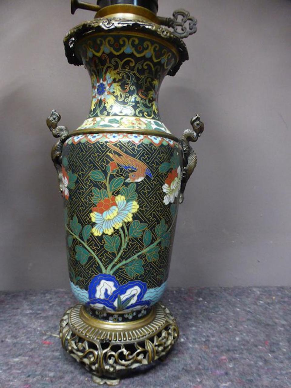 19th century Pair of enamel lamps finely cloisonné plant pattern on a black background. The gilt bronze feet are openwork, the shoulders are decorated with small bronze dragons rising on the vases.