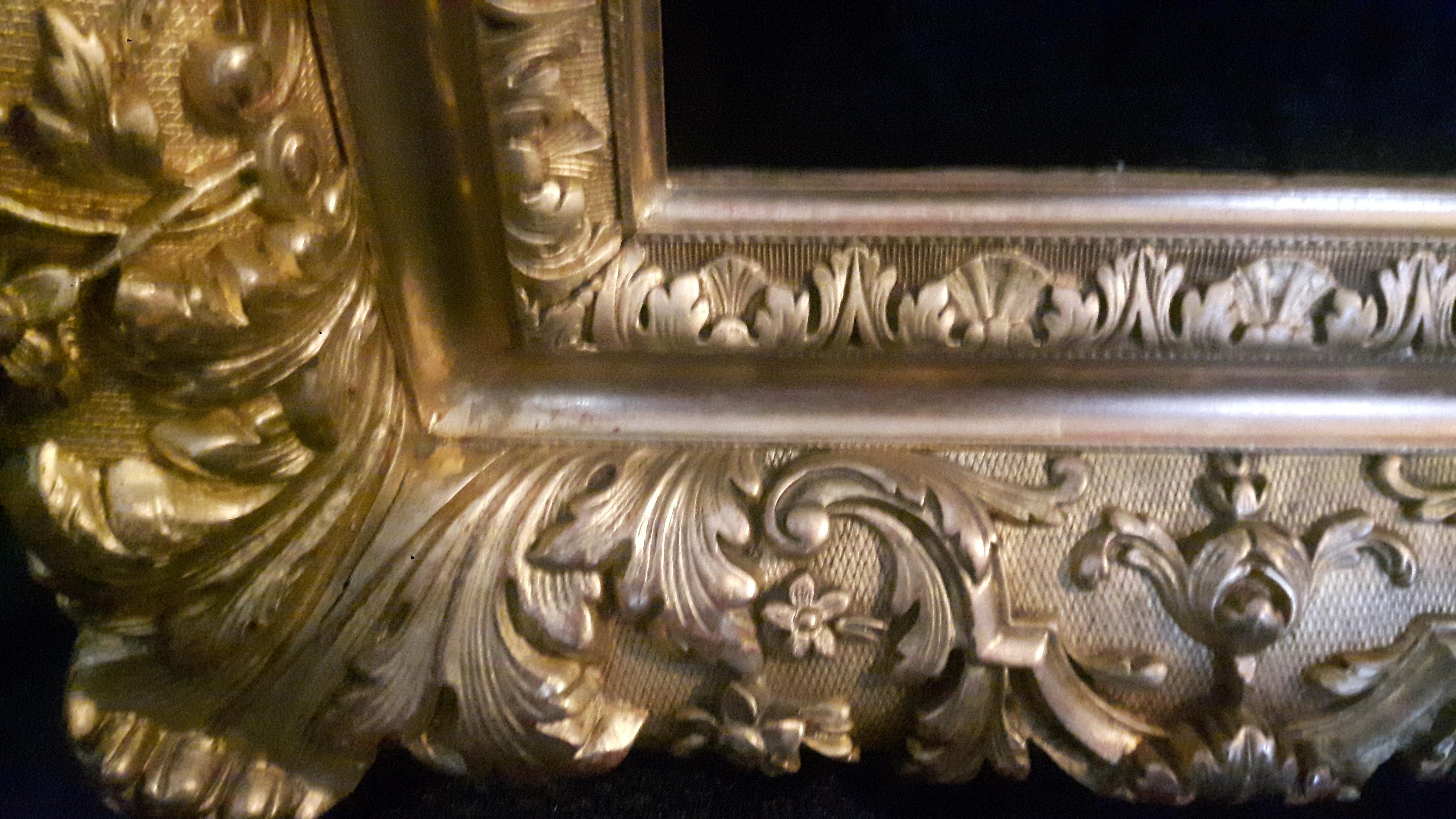 A highly detailed late 19th century gold metal leaf cover frame decorated in golden floral motifs.
