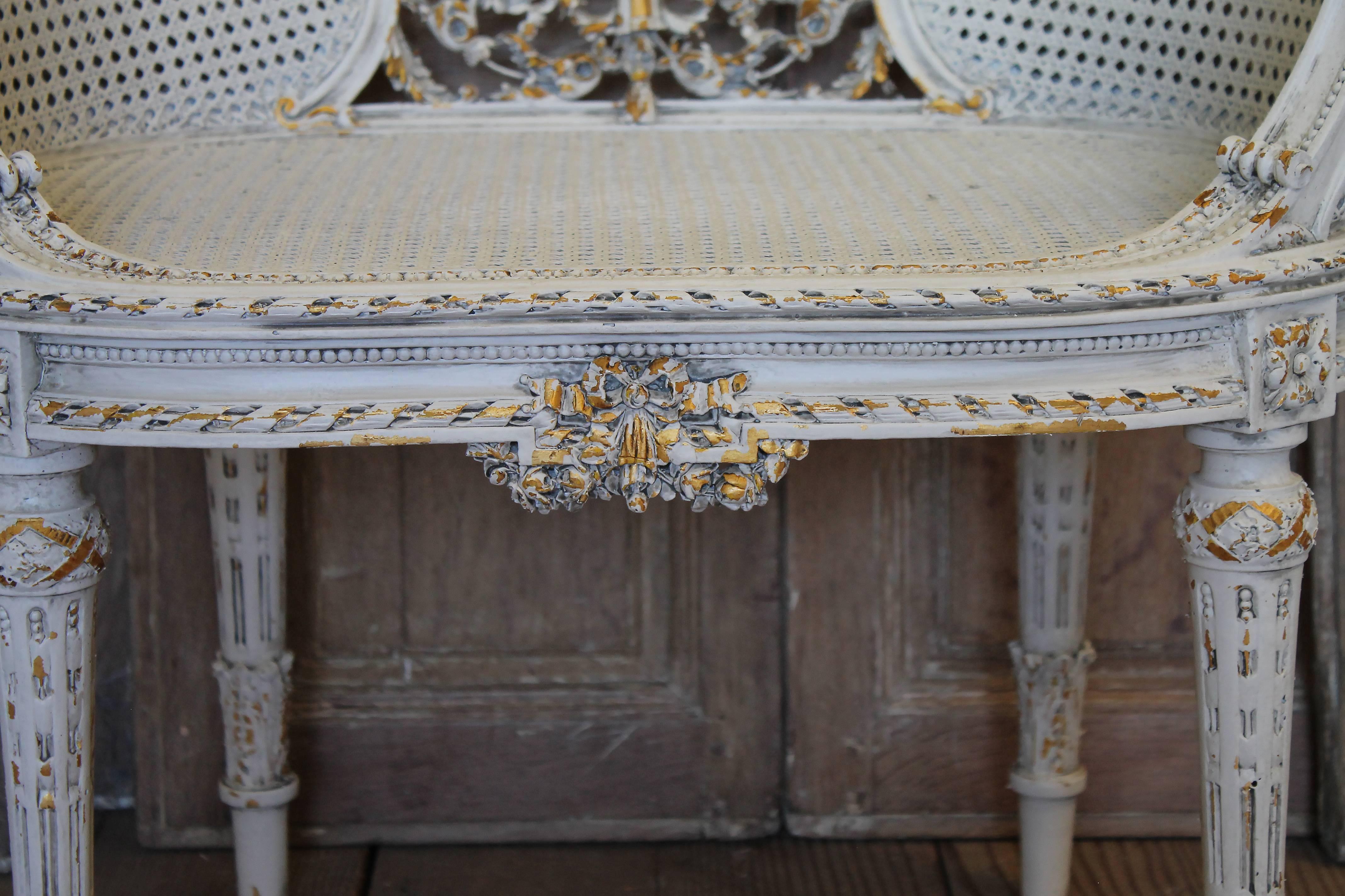 Fabulous painted giltwood chair with intricate carved details. This low back carved Louis XVI style chair is original double cane back, and caned seat with a custom upholstered seat cushion that is removable. There are vines of detailed carved roses