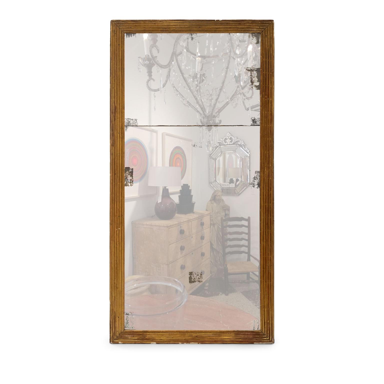 Encadrement de miroir en bois doré cannelé du début du 19e siècle entourant une plaque de séparation en miroir au mercure d'origine. Le verre miroir présente des pertes au revers argenté et de la poussière de diamant sur les bords.

Note : Les