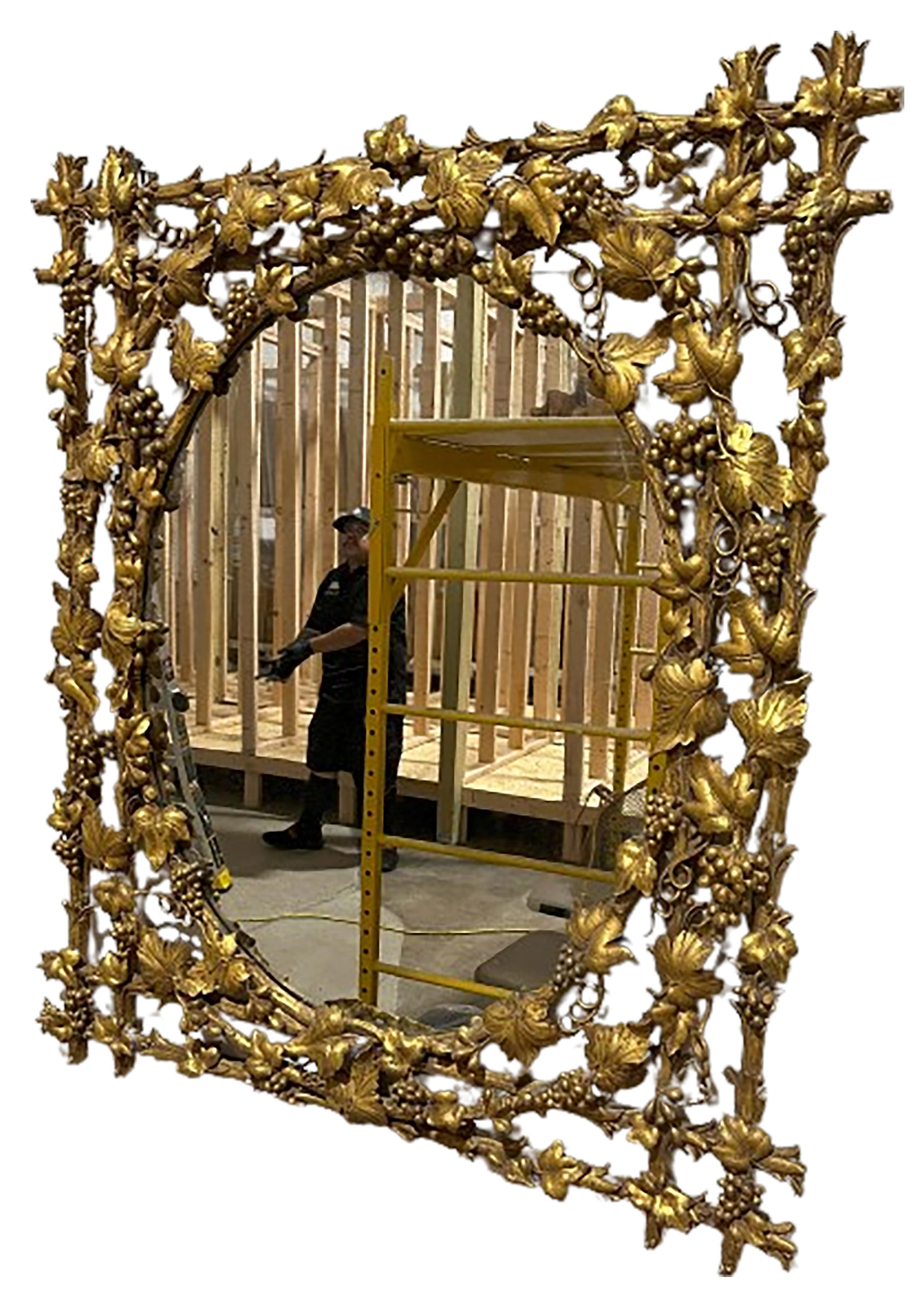 A handsome giltwood ventilated carved mirror. Carved vines, grapes, and branches. Oval shaped glass insert. Created circa 19th century.

No obvious markings on the piece. 

In good condition. Some gentle wear consistent with age and use.  

This