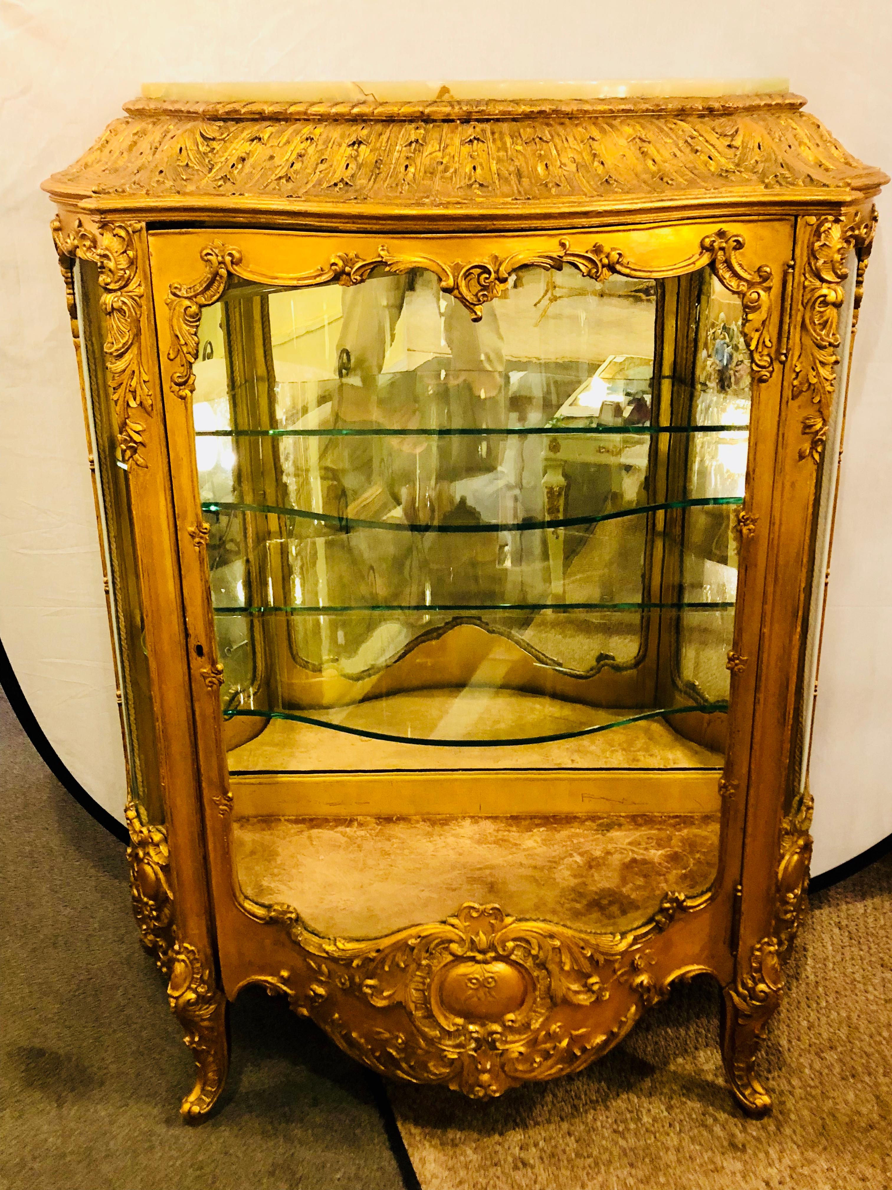 A 19th century giltwood Louis XV carved Curio vitrine showcase cabinet. This is simply the finest vitrine or curio one could possibly wish for. The finely carved frame having scroll floral flame leaf and vine work of the finest detail all done in a