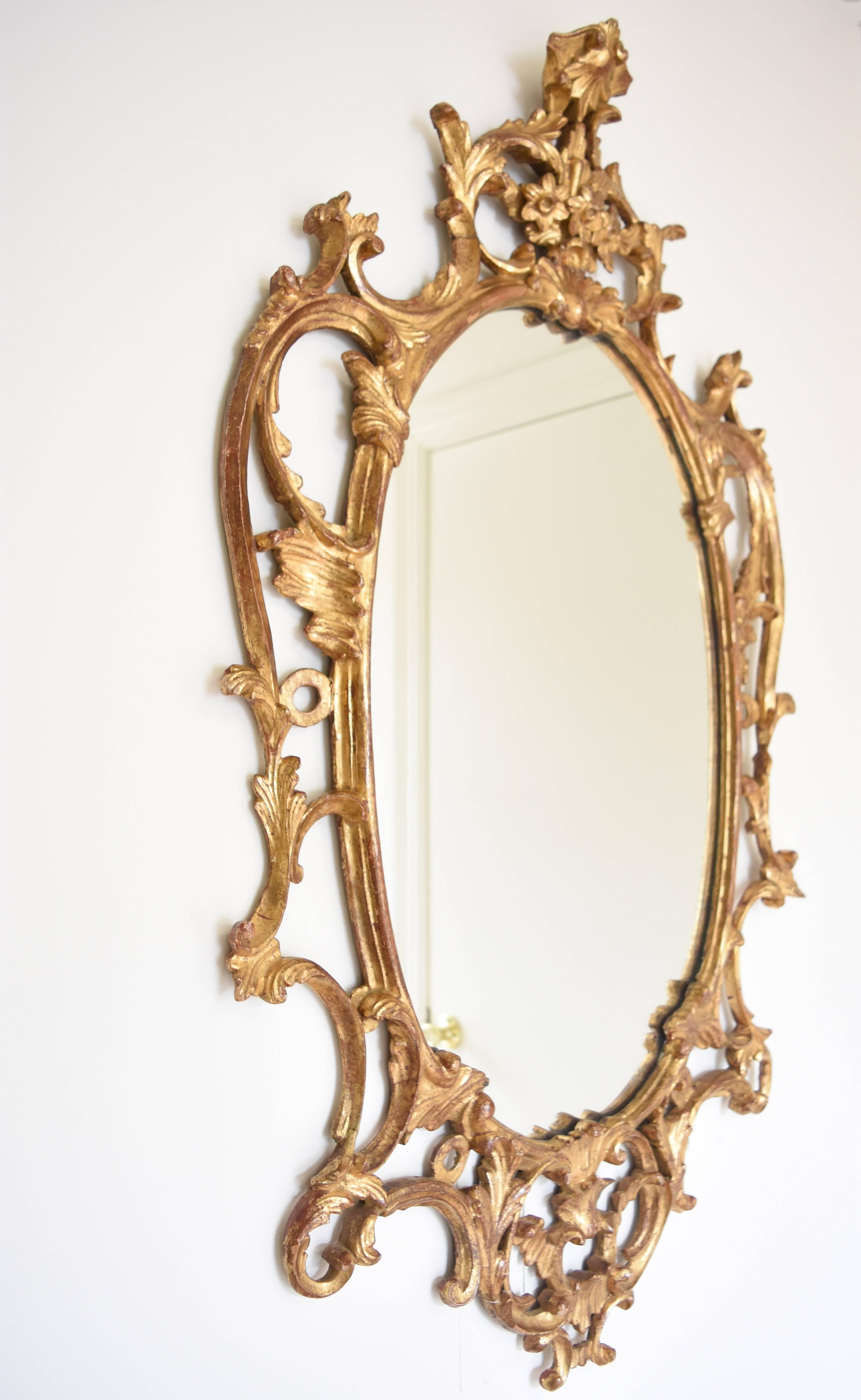 This 19th century giltwood mirror is likely English. It is adorned with finely carved c-scrolls, acanthus leaves and flowers.