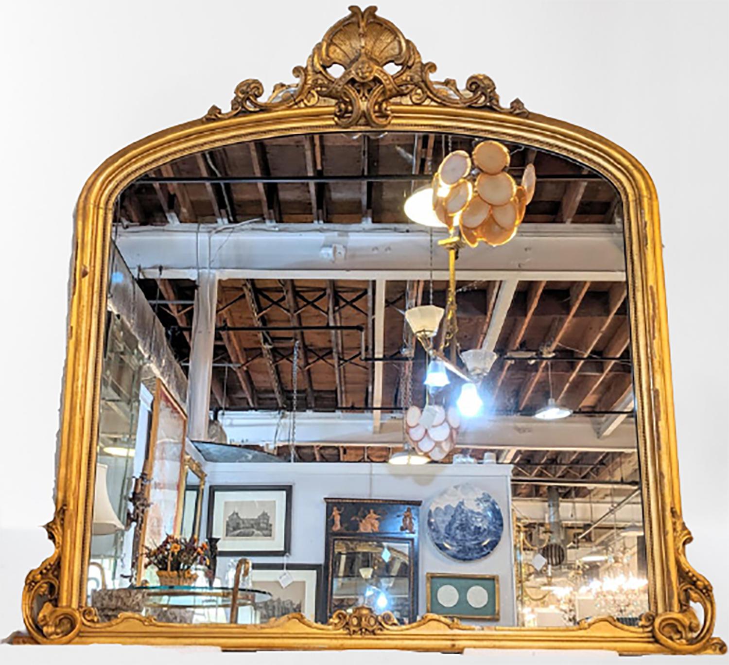 19th century giltwood mirror. Wall, console or over the mantel (fireplace) fireplace mirror. This palatial finely gilt wall or console mirror was found in a Greenwich Ct Mansion sitting atop a large fireplace. The finest quality gilt with a carved