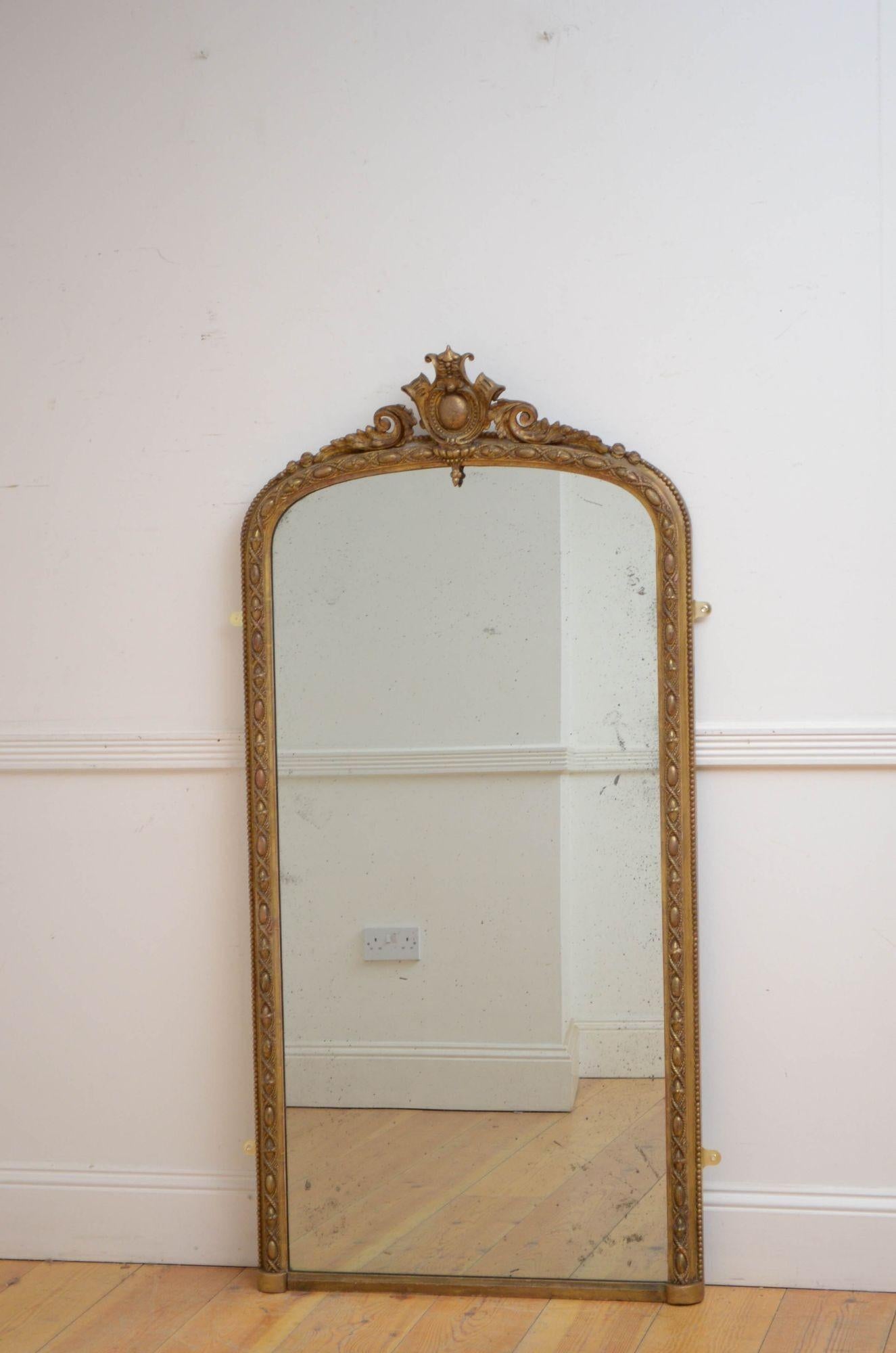 J027 Victorian gilded console table mirror or wall mirror, having original foxed glass in gilded, arched and finely frame with beaded outer edge and scroll crest to the centre. This antique mirror retains its original glass, original gilt and