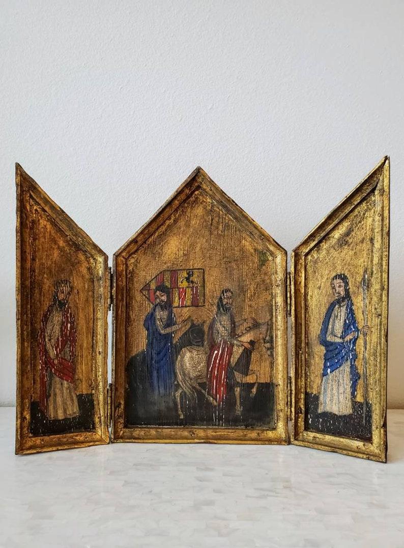 A beautiful 19th century hand carved and painted partial git live edge wooden triptych retable church altarpiece, depicting 