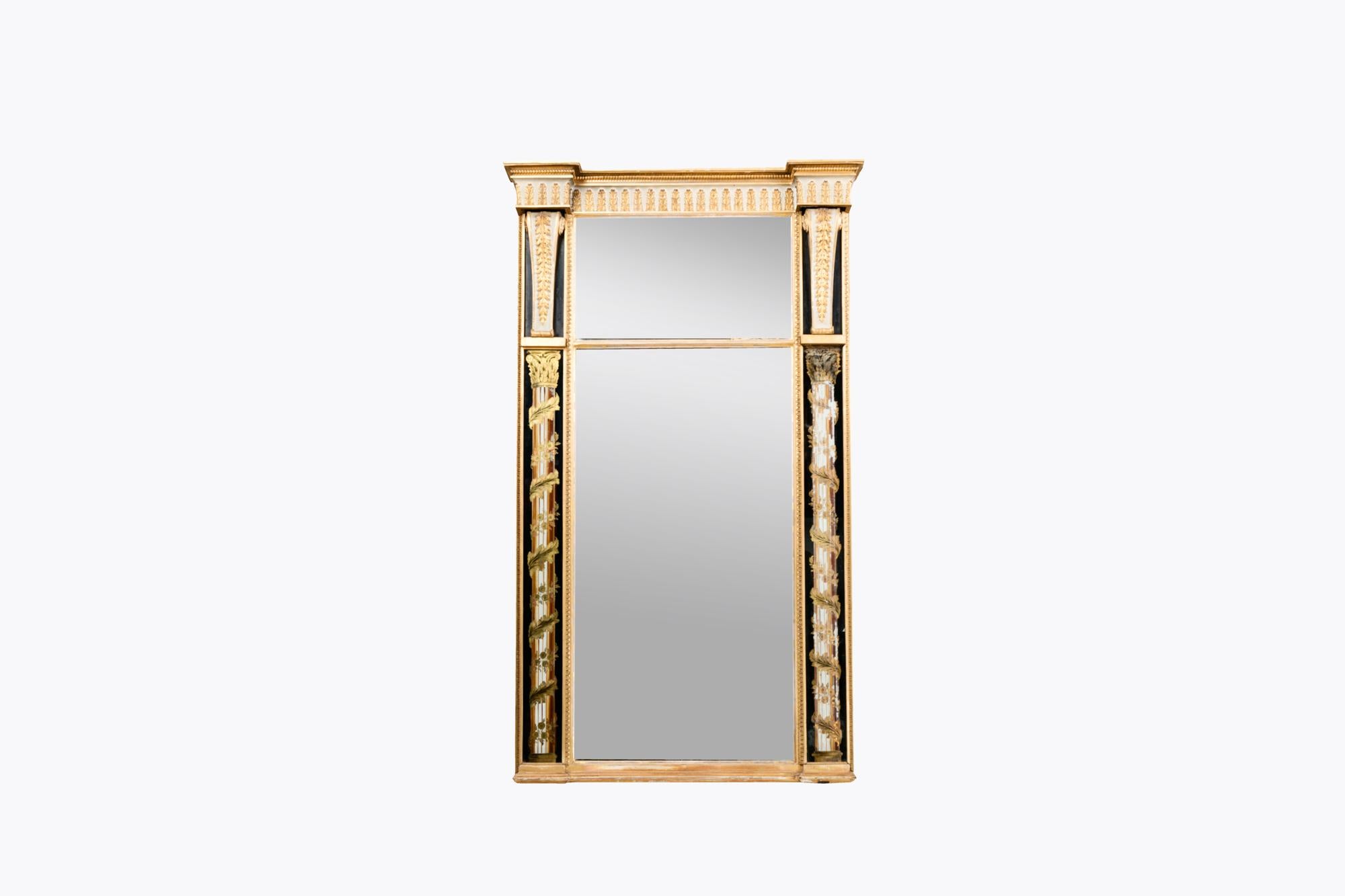 Miroir tabernacle en bois doré du XIXe siècle, flanqué d'un décor d'Églomisé peint à la main représentant des colonnes corinthiennes avec des vignes grimpantes. Surmontée d'une corniche sculptée de rinceaux, de feuillages et de perles.