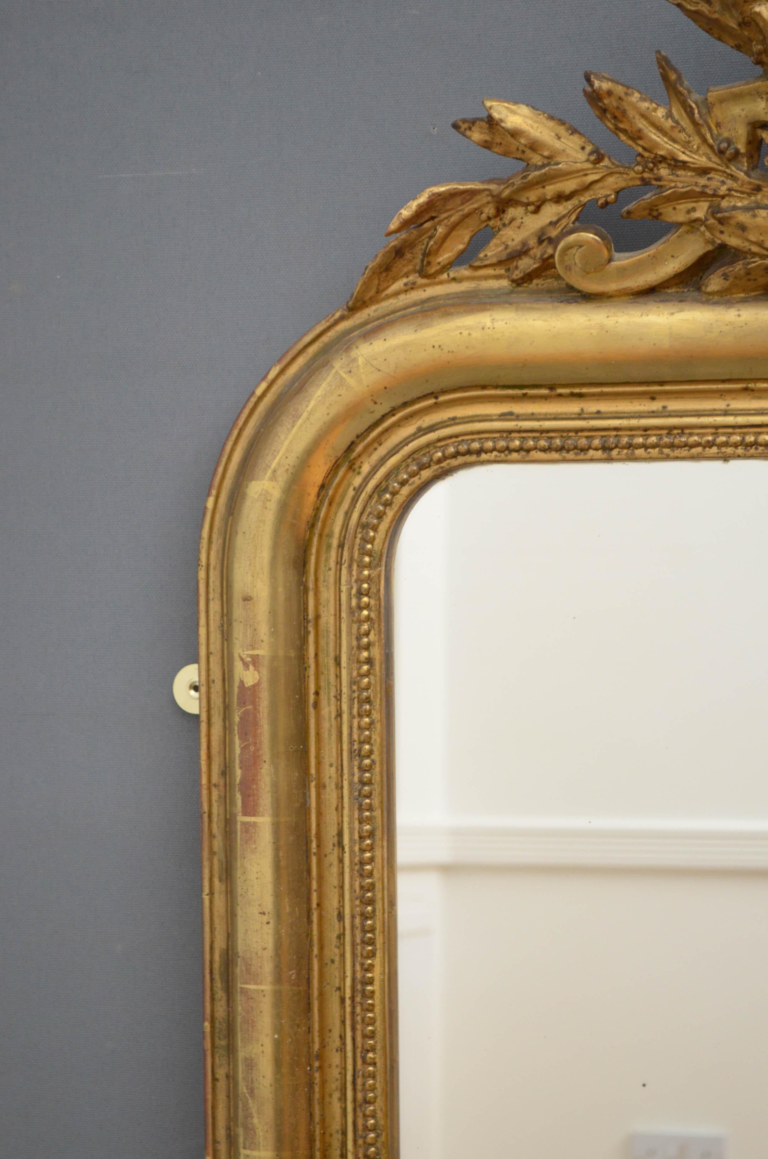 Sn4805, very attractive 19th century gilded mirror, having original glass with some foxing in decorative frame with foliage scrolls to base and leafy crest to the top enclosing small bevelled edge mirror. This antique mirror retains its original