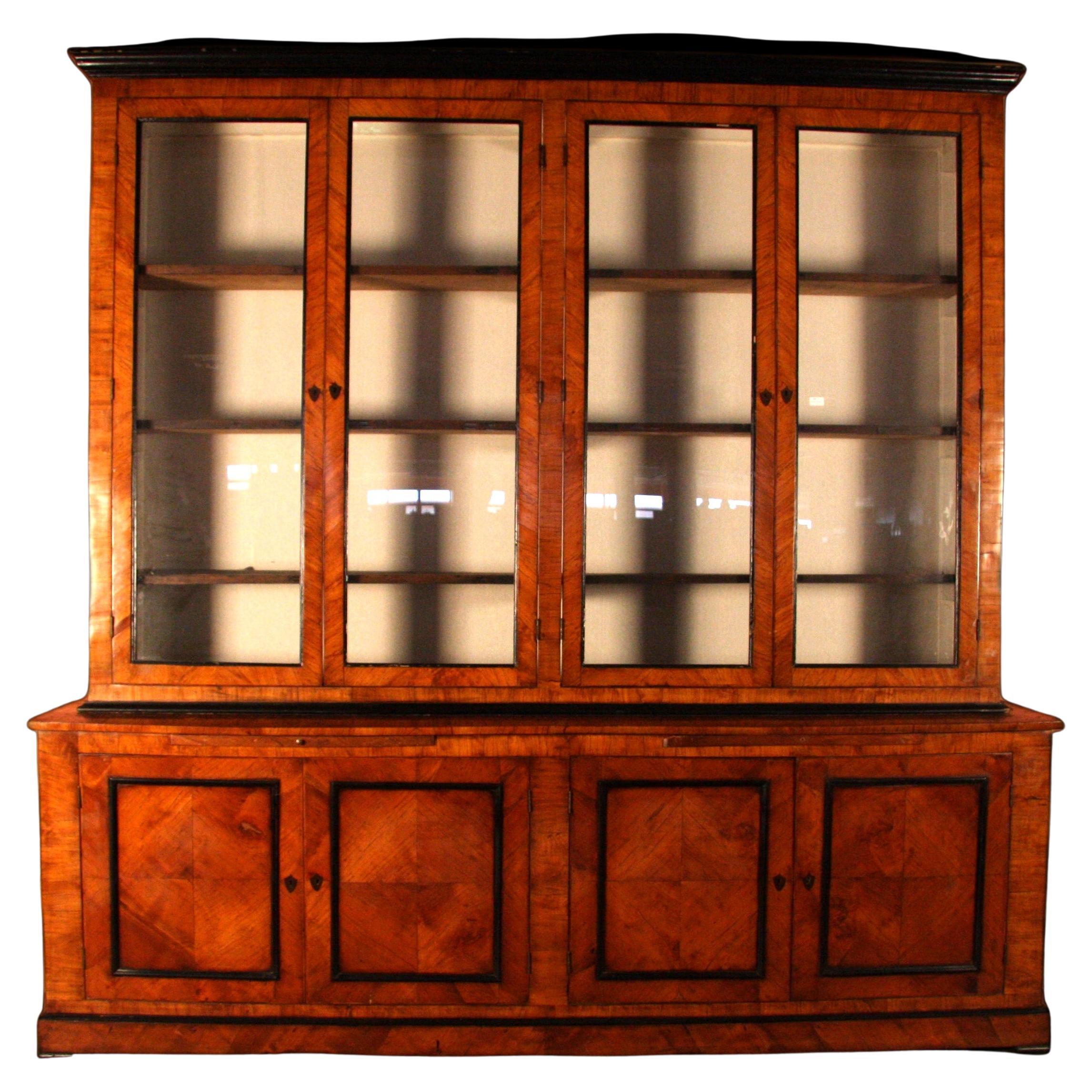 Glass bookcase with 4 doors and 4 flaps, veneered in Olive wood and with ebonized profiles.

In excellent condition, already restored in a conservative way.

Bookcase of the first years of 1800. 
Provenance: Italy.
 
Measurements: length of the base