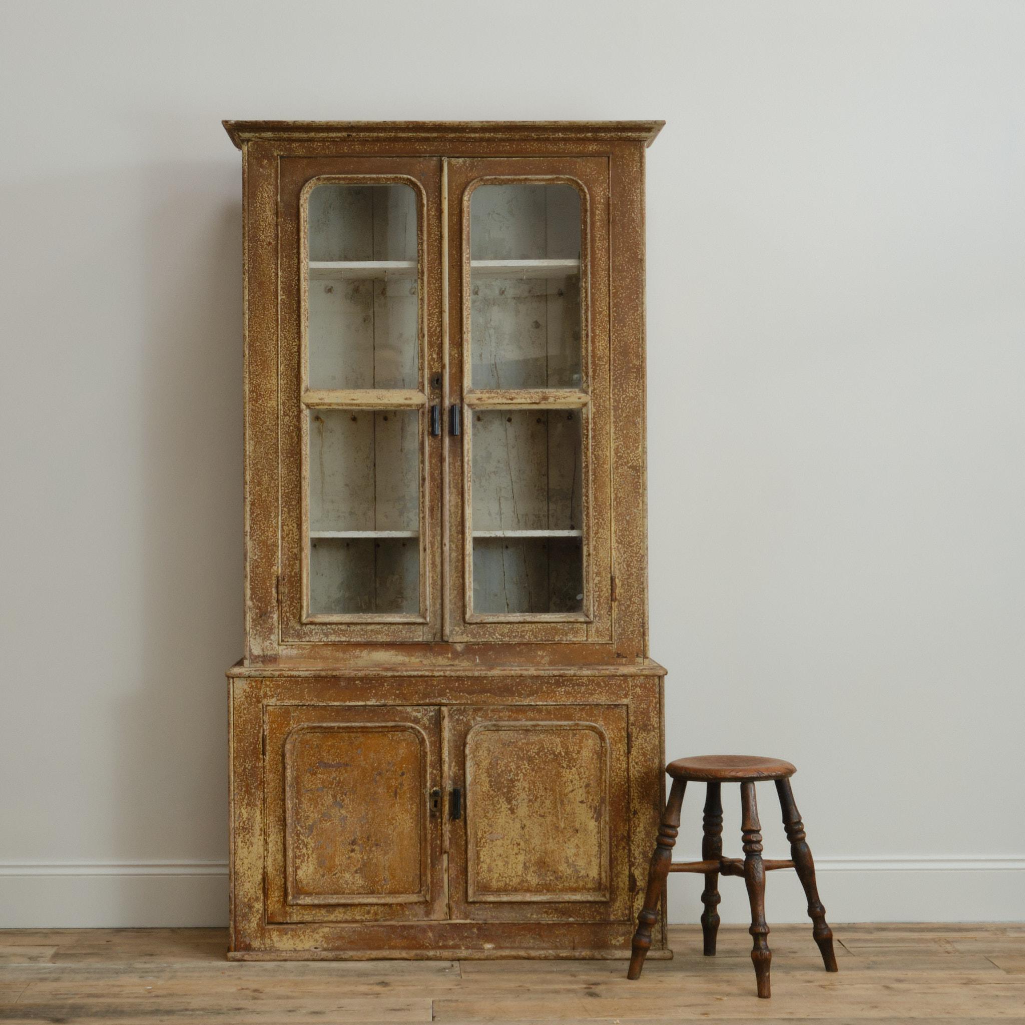 Une très belle armoire vitrée du 19ème siècle avec un extérieur peint en croûte sèche merveilleusement usé. 

Condition . Pertes diverses, peinture usée, étagères intérieures peintes marquées, poignées postérieures. La fermeté est de mise