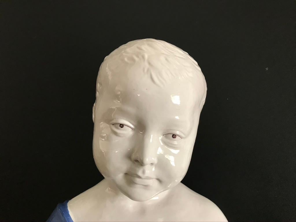 Exceedingly charming ceramic 'Busto di Bambino' in the Italian Renaissance style. With the blue and white glaze typical of artist Andrea Della Robbia, this bust is modeled after the marble original by Fifteenth century Italian master, Desiderio da