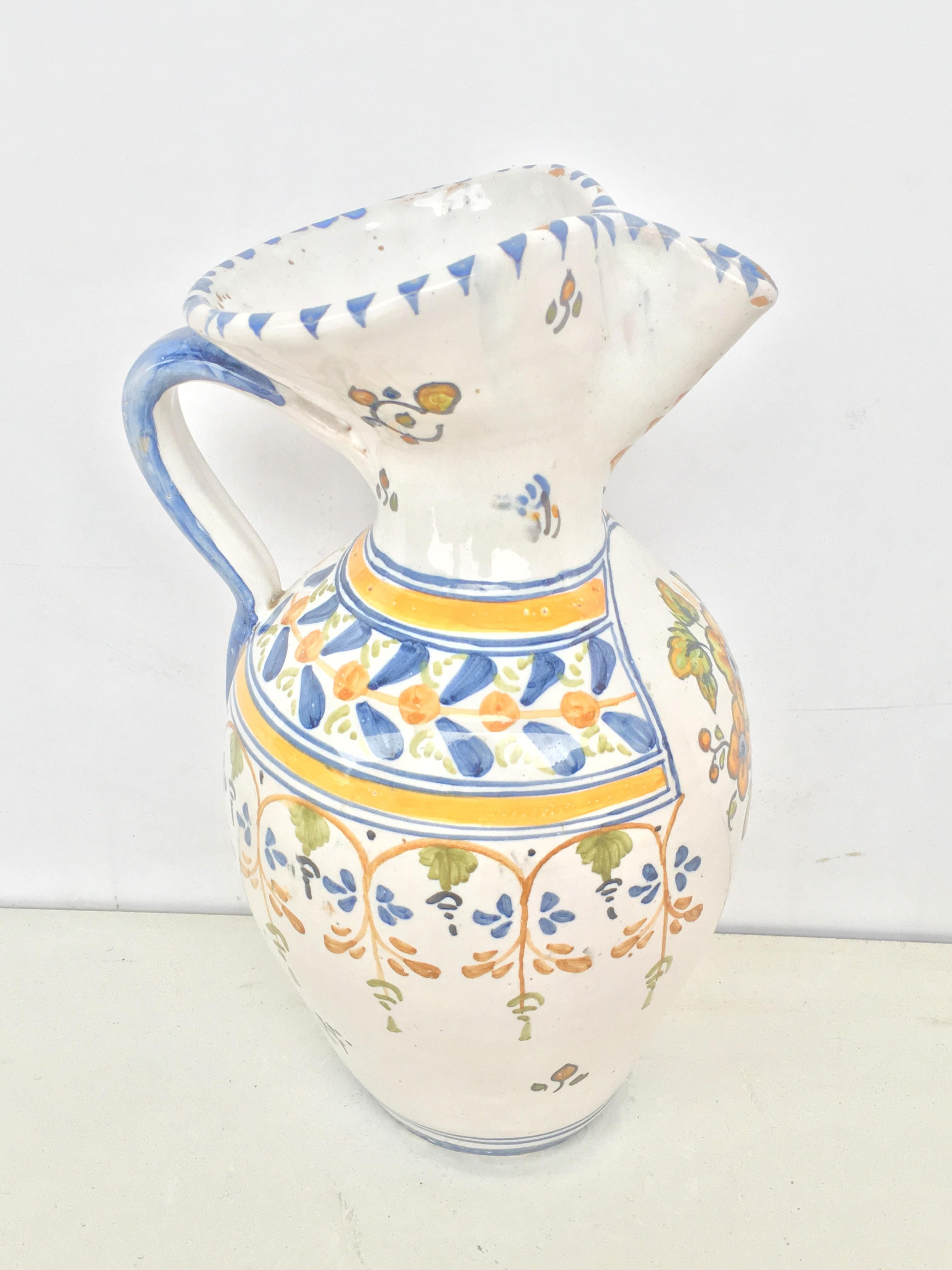 A striking Spanish glazed earthenware handled yellow, green and blue painted pitcher, the body underglaze floral decorated 

Talavera de la Reina pottery is a craft made in Talavera de la Reina, Toledo (Spain). Dishes, jars and other objects have