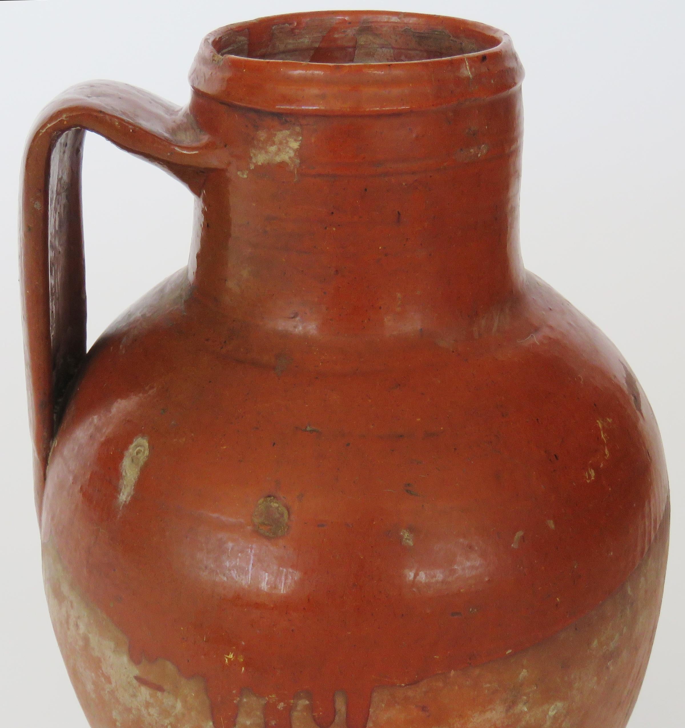 Hand coiled glazed jug with slim neck and large handle.