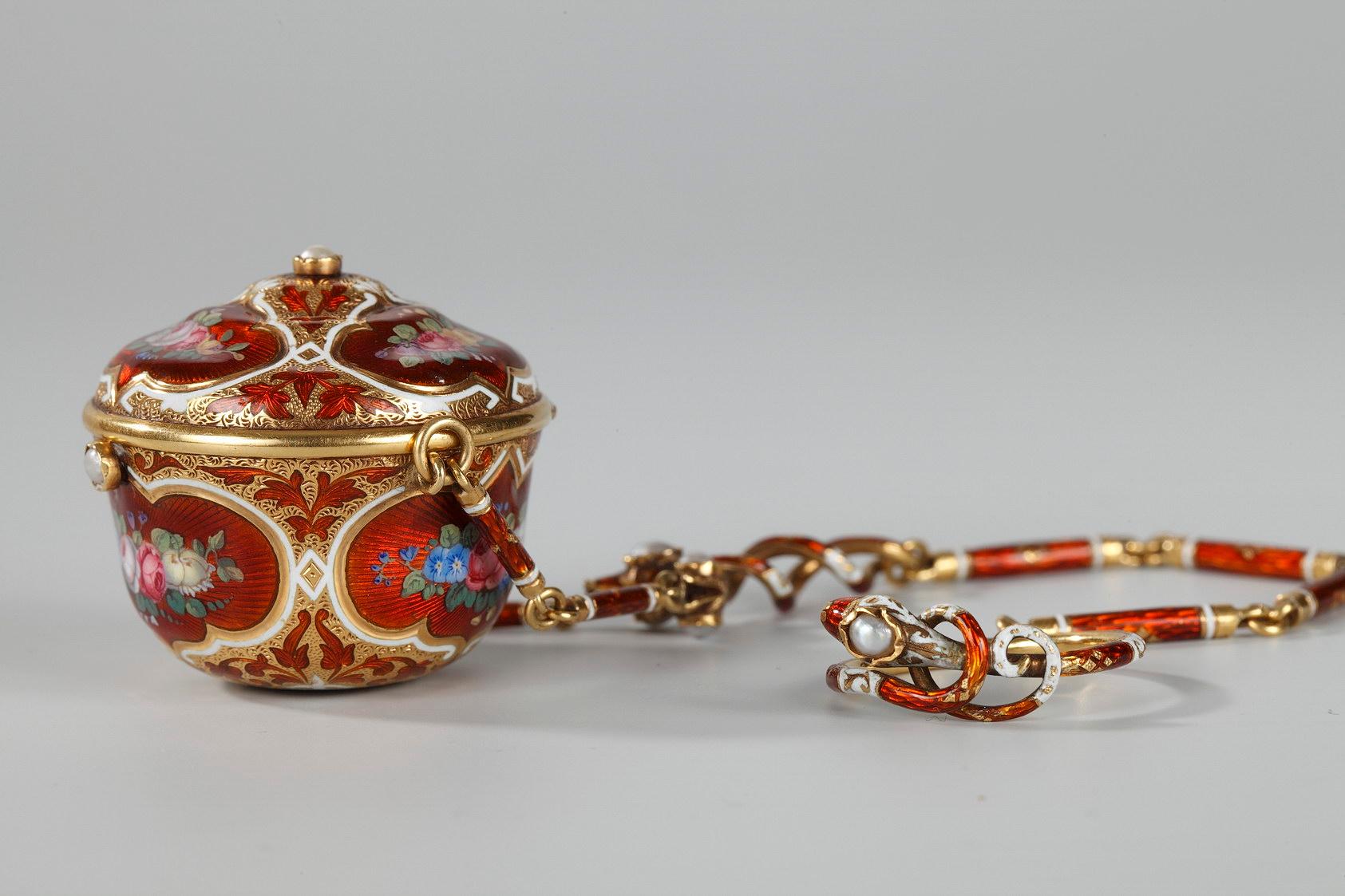 Small vinaigrette in gold and enamel. The miniature basin, which was used to hold fabric or cotton infused with fragrance, and its lid are decorated with multicolored bouquets of flowers framed in white and gold scrollwork and rinceau on a red