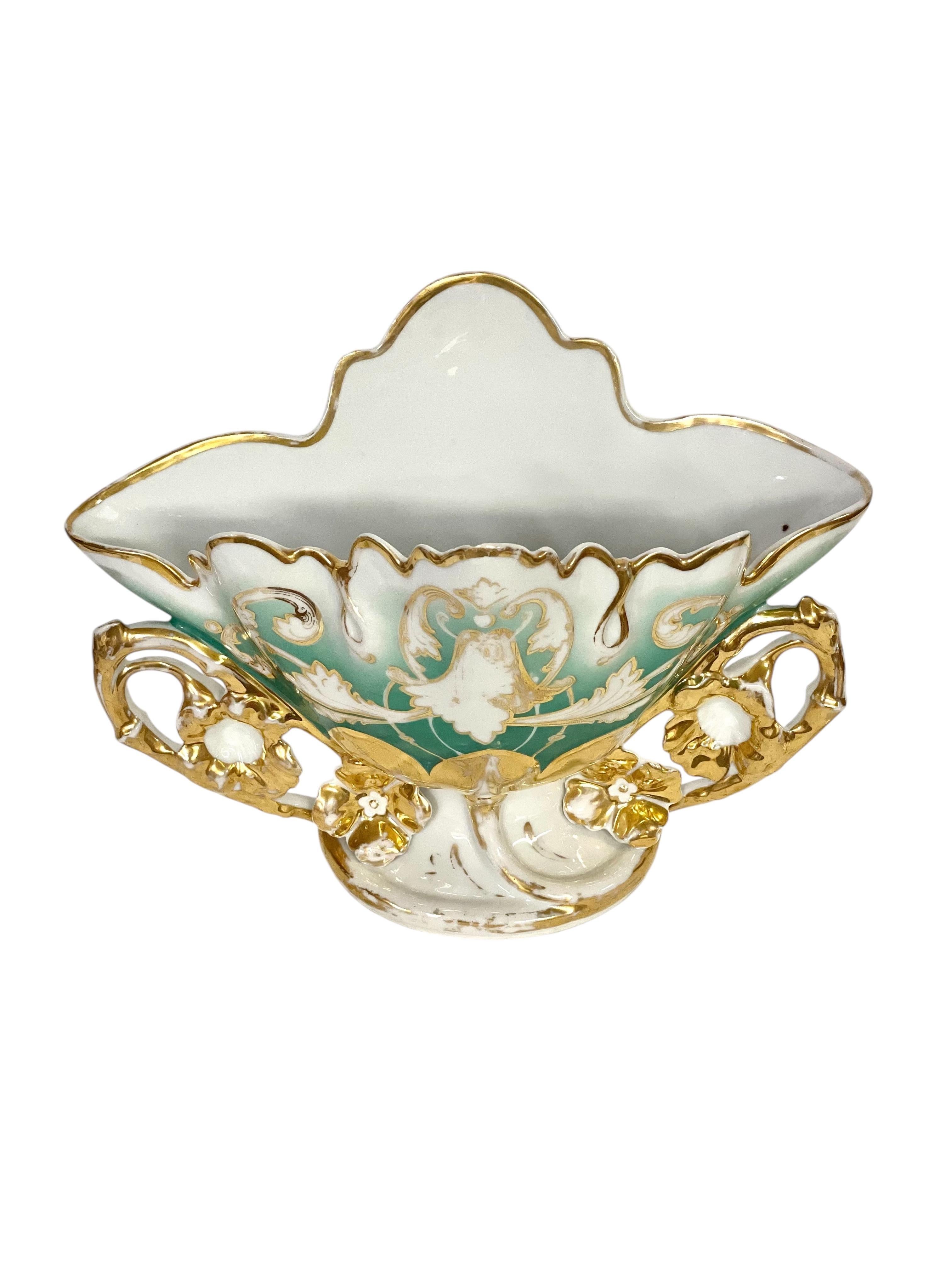 Questo squisito vaso di porcellana antico è una testimonianza dell'arte e della maestria del XIX secolo. Realizzato in porcellana fine, questo vaso è ornato da intricati motivi floreali dipinti a mano in oro vibrante e colori delicati. I delicati