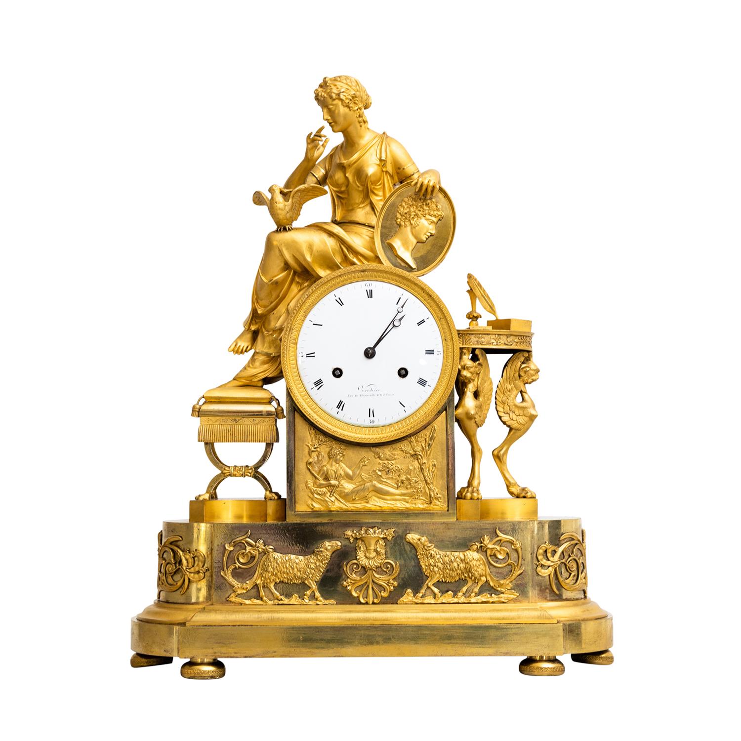 A gold, antique French table clock, pendulum made of hand crafted fire-gilded bronze, in good condition. The circular enamel dial of the Parisian pendule is detailed with Roman numerals and Arabic quarter markers on a white background,
